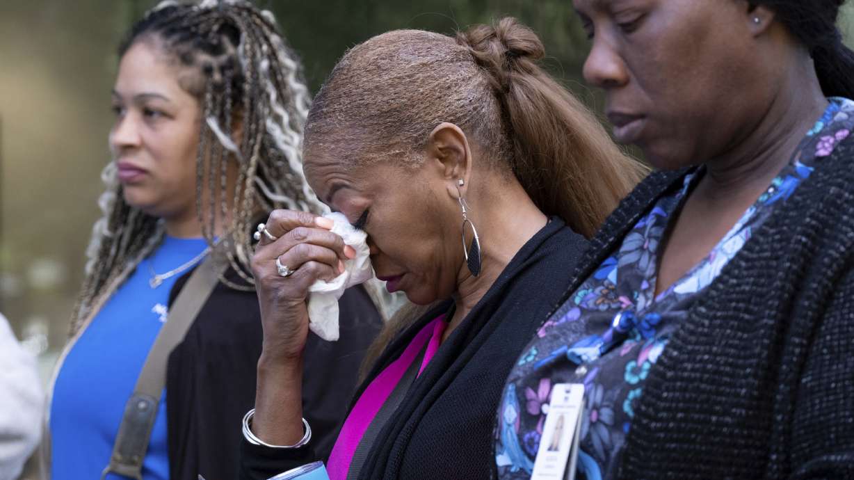 A woman tears up after evacuating following a shooting at a medical building in Midtown Atlanta on Wednesday. Police say they have apprehended a man who allegedly opened fire inside the waiting room of the medical facility, killing one woman and injuring four others.