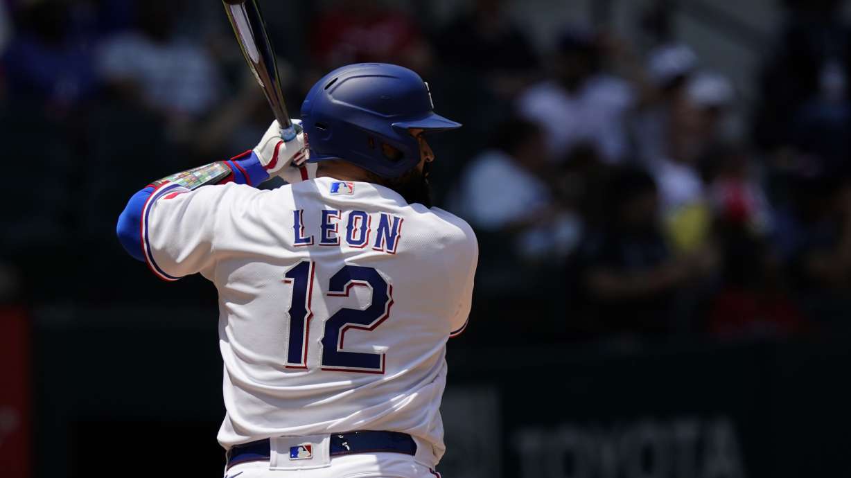 Texas Rangers' Sandy Leon (12) stands at bat during a baseball game against the Arizona Diamondbacks in Arlington, Texas, Wednesday, May 3, 2023. Veteran big league catcher Sandy León changed his uniform to No. 12 this season with the Texas Rangers to remind himself of the worst day of his life.