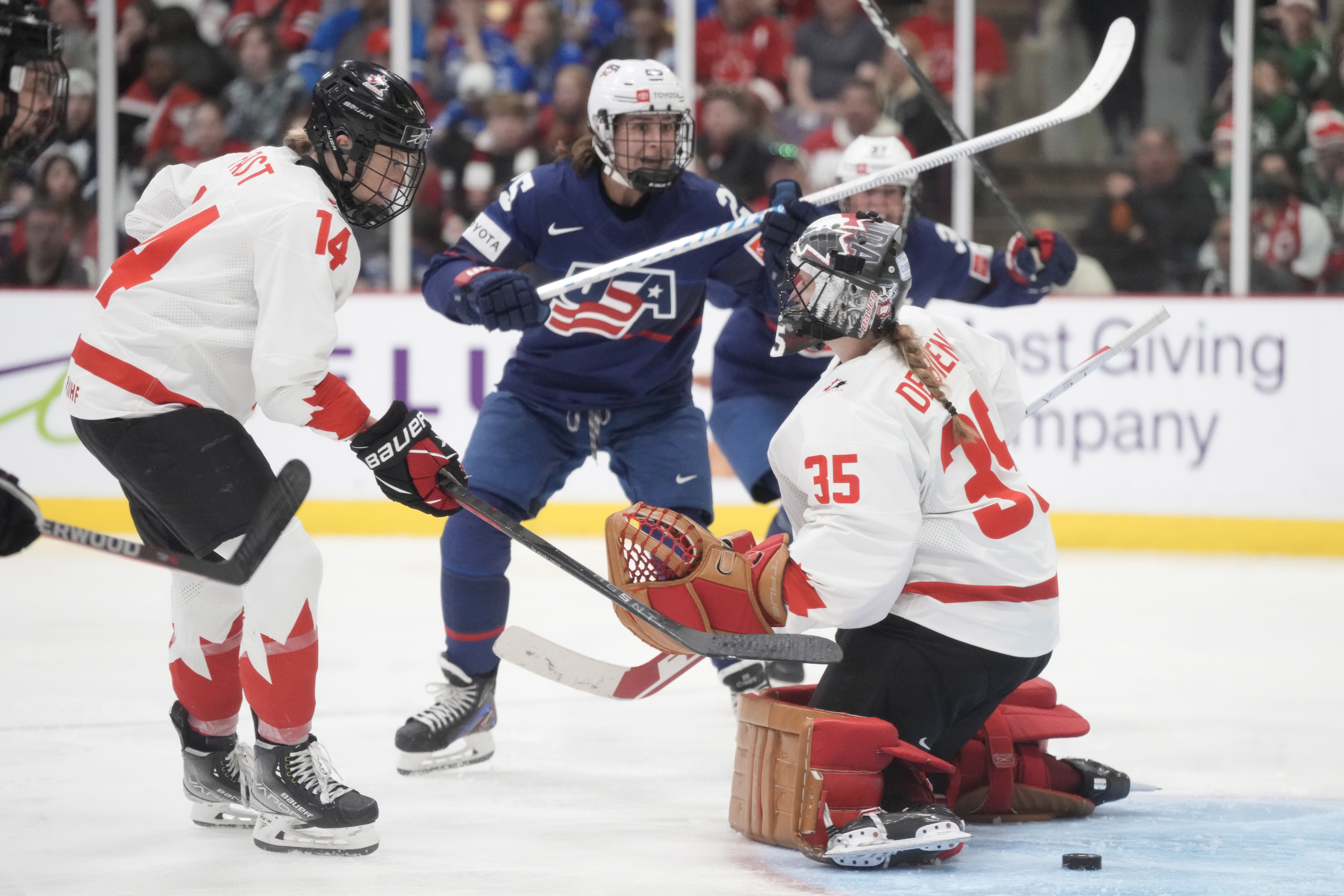 FILE - United States players celebrate as Canada goaltender Ann-Renee Desbiens (35) and teammate defender Renata Fast (14) react after United States defender Caroline Harvey scored during the third period of the gold medal game at women's world hockey championships in Brampton, Ontario, Sunday, April 16, 2023. Last month’s world championship gold-medal victory aside, United States women’s hockey players have fallen behind their Canadian rivals in terms of compensation, two people with direct knowledge of the each national teams’ contracts revealed to The Associated Press this week.