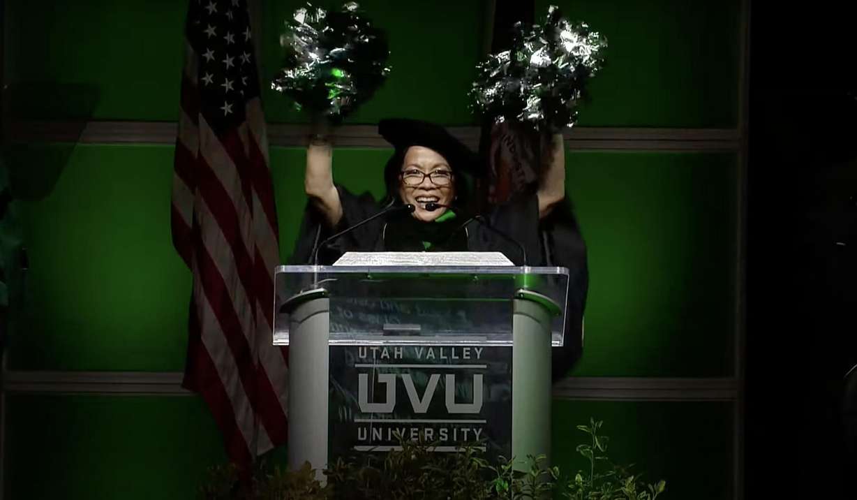 UVU President Astrid S. Tuminez shakes green and silver pompoms at the university's 2023 commencement ceremony in Orem on Thursday.