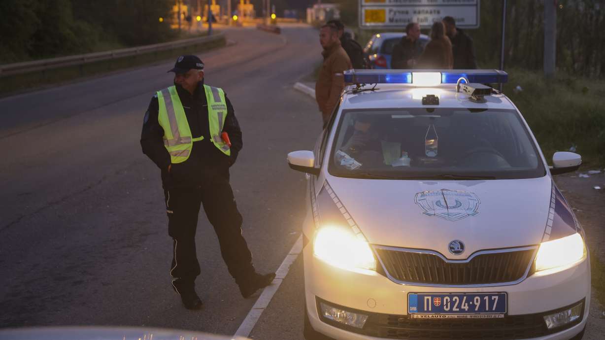 Police officers block the road near Mali Pozarevac, some 30 miles south of Belgrade, Serbia, Friday. A shooter killed at least eight people and wounded 13 in a drive-by attack late Thursday.