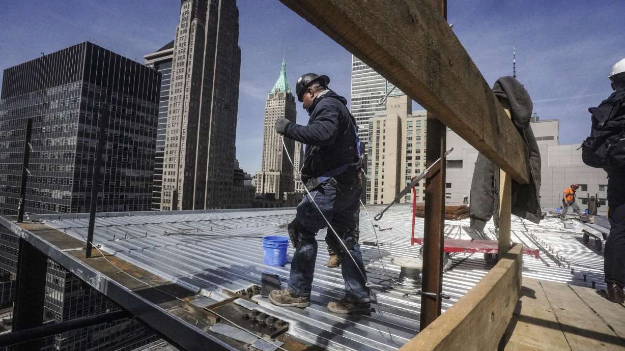 Construction workers install roofing on a high rise in Manhattan's financial district on April 11, in New York. On Friday, the U.S. government issued the April jobs report.
