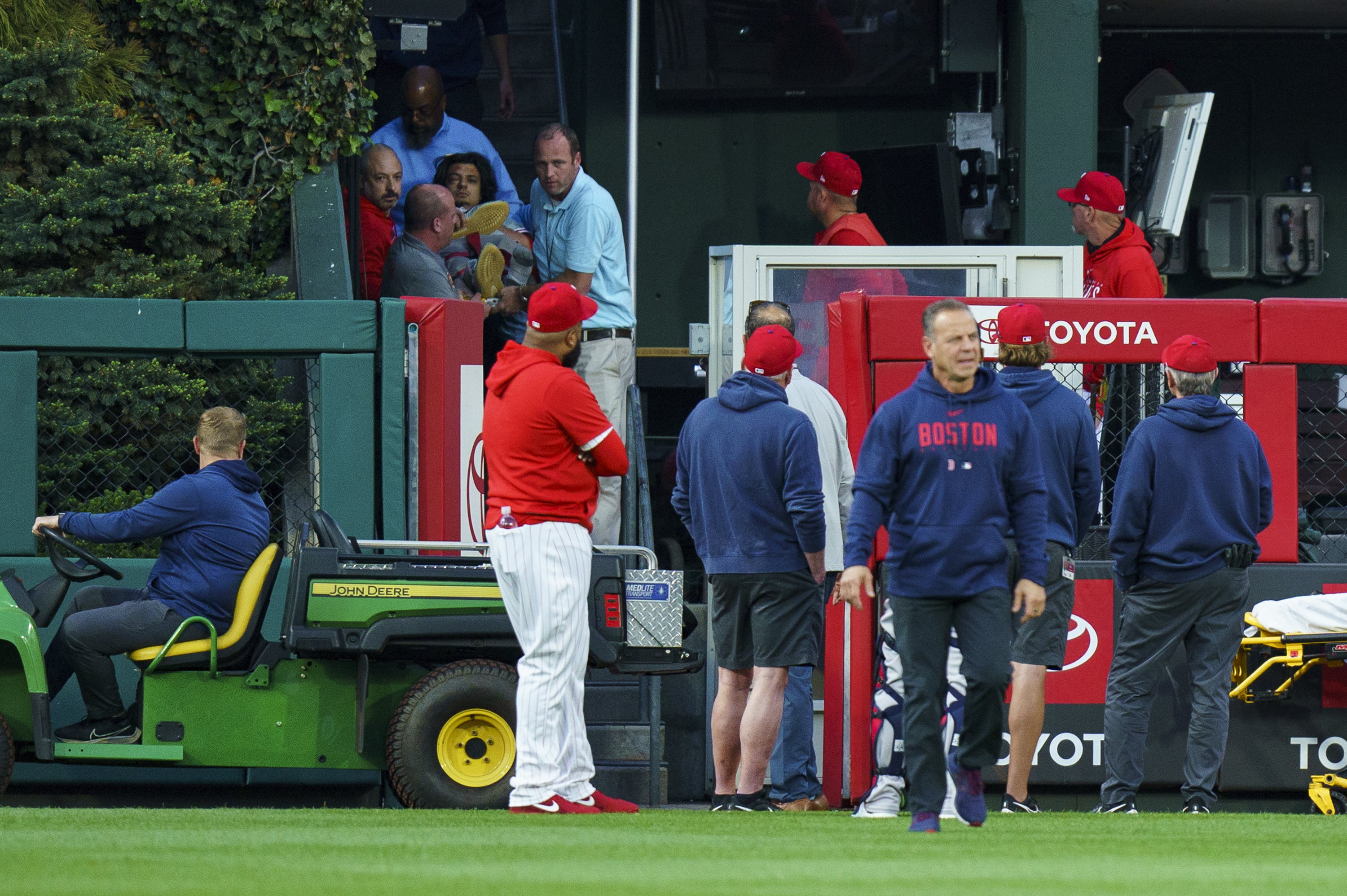 A fan, who fell into the Boston Red Sox bullpen, is brought down by the medical staff during the first inning of a baseball game against the Philadelphia Phillies, Friday, May 5, 2023, in Philadelphia. 