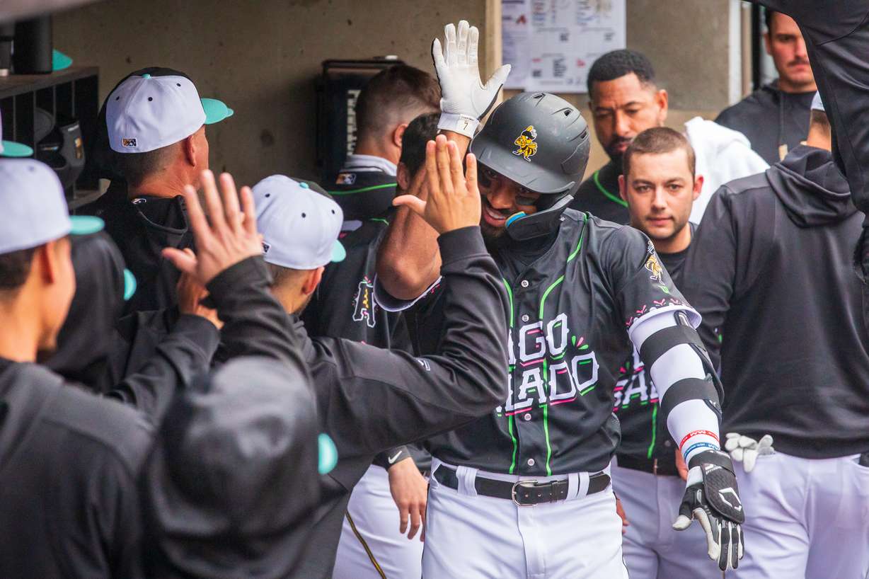 Salt Lake Bees players slap hands with Bees outfielder Jo Adell in the dugout after he slugs a home run against the Reno Aces on April 22. Adell has 12 home runs in 29 games this season