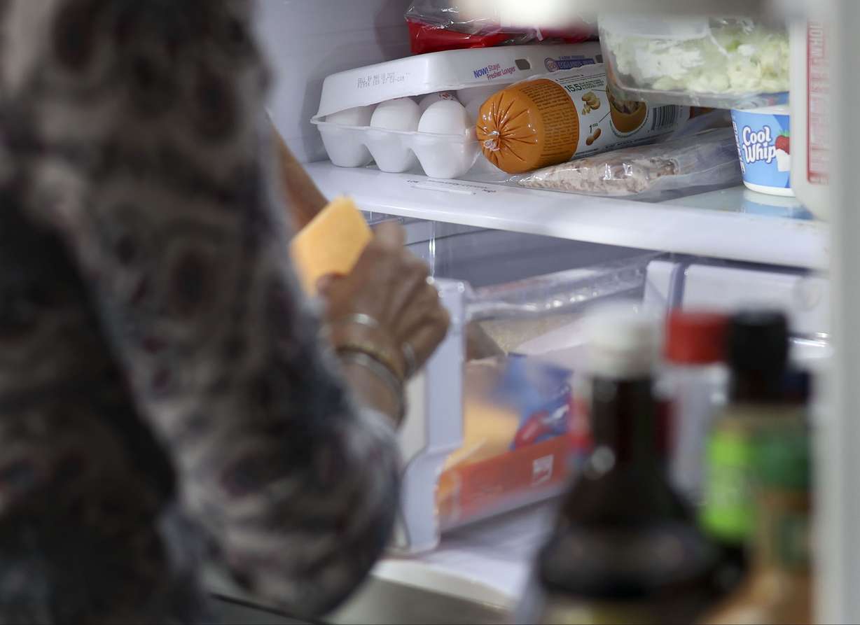 Lisa Conley gets sandwich ingredients from the refrigerator in her Marriott-Slaterville home on May 5.