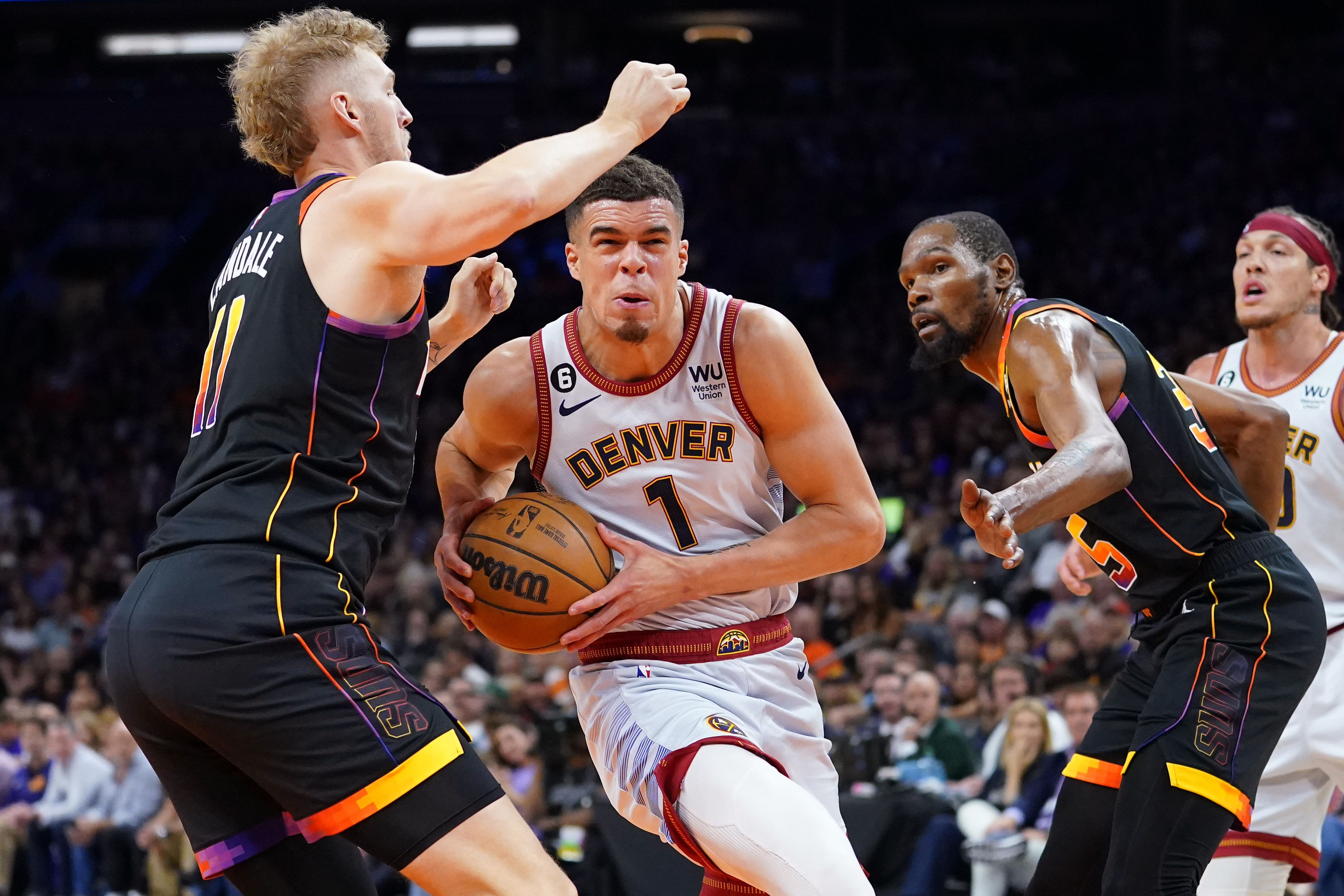 Denver Nuggets forward Michael Porter Jr. (1) drives between Phoenix Suns center Jock Landale, left, and forward Kevin Durant, right, during the second half of Game 3 of an NBA basketball Western Conference semifinal game, Friday, May 5, 2023, in Phoenix. The Suns defeated the Nuggets 121-114. 