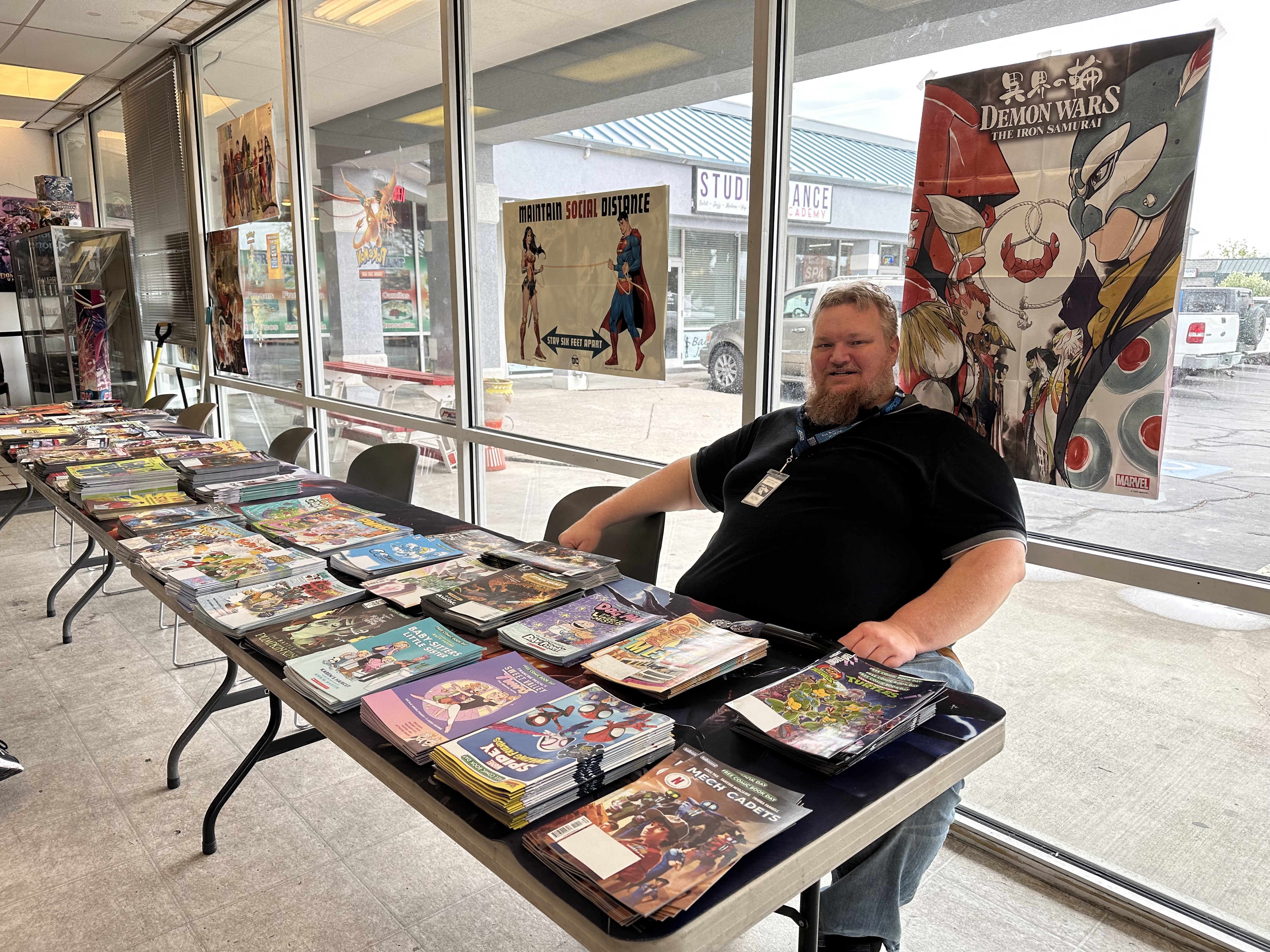Seth Dodge, general manager of Dragon's Keep in Orem, passes out free comics to customers during Free Comic Book Day on Saturday.