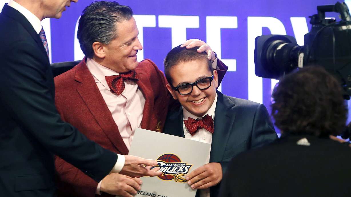 FILE - In this May 21, 2013, file photo, Cleveland Cavaliers owner Dan Gilbert congratulates his son, Nick Gilbert, after the team won the NBA basketball draft lottery in New York. Nicolas “Nick” Gilbert, who became the team's good luck charm at NBA draft lotteries, has died. He was 26. A funeral announcement posted by the Ira Kaufman Chapel said Gilbert died Saturday, May 6, 2023 “peacefully at home surrounded by family.”
