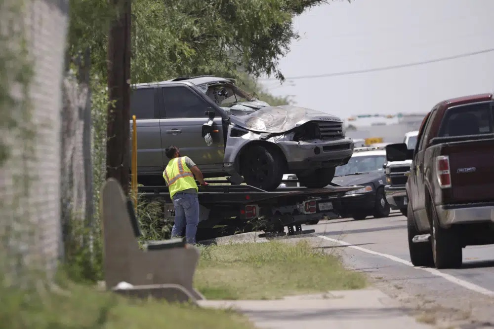 Emergency personnel take away a damaged vehicle after a fatal collision in Brownsville, Texas, on Sunday. Several migrants were killed after they were struck by a vehicle while waiting at a bus stop near Ozanam Center, a migrant and homeless shelter.