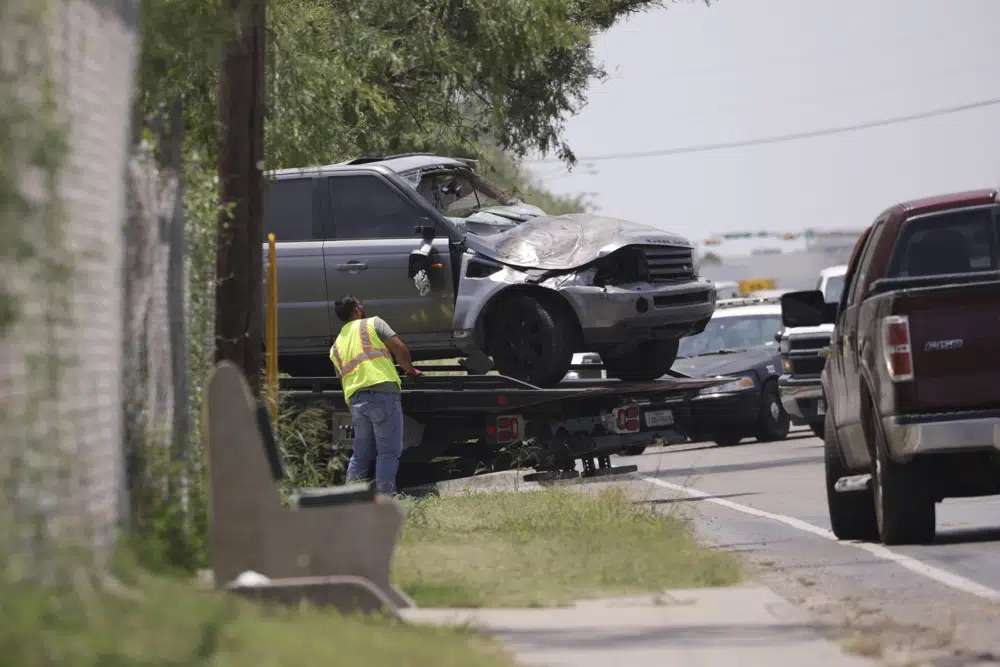 Emergency personnel take away a damaged vehicle after a fatal collision in Brownsville, Texas, on Sunday. Several migrants were killed after they were struck by a vehicle while waiting at a bus stop near Ozanam Center, a migrant and homeless shelter.