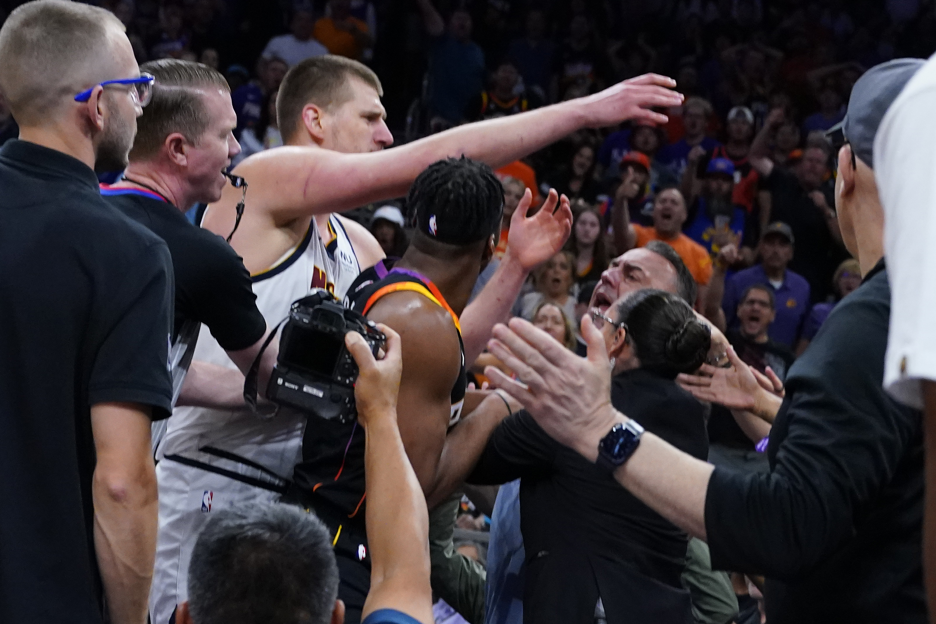 Denver Nuggets center Nikola Jokic get into an altercation in the stands during the first half of Game 4 of an NBA basketball Western Conference semifinal game against the Phoenix Suns, Sunday, May 7, 2023, in Phoenix. 