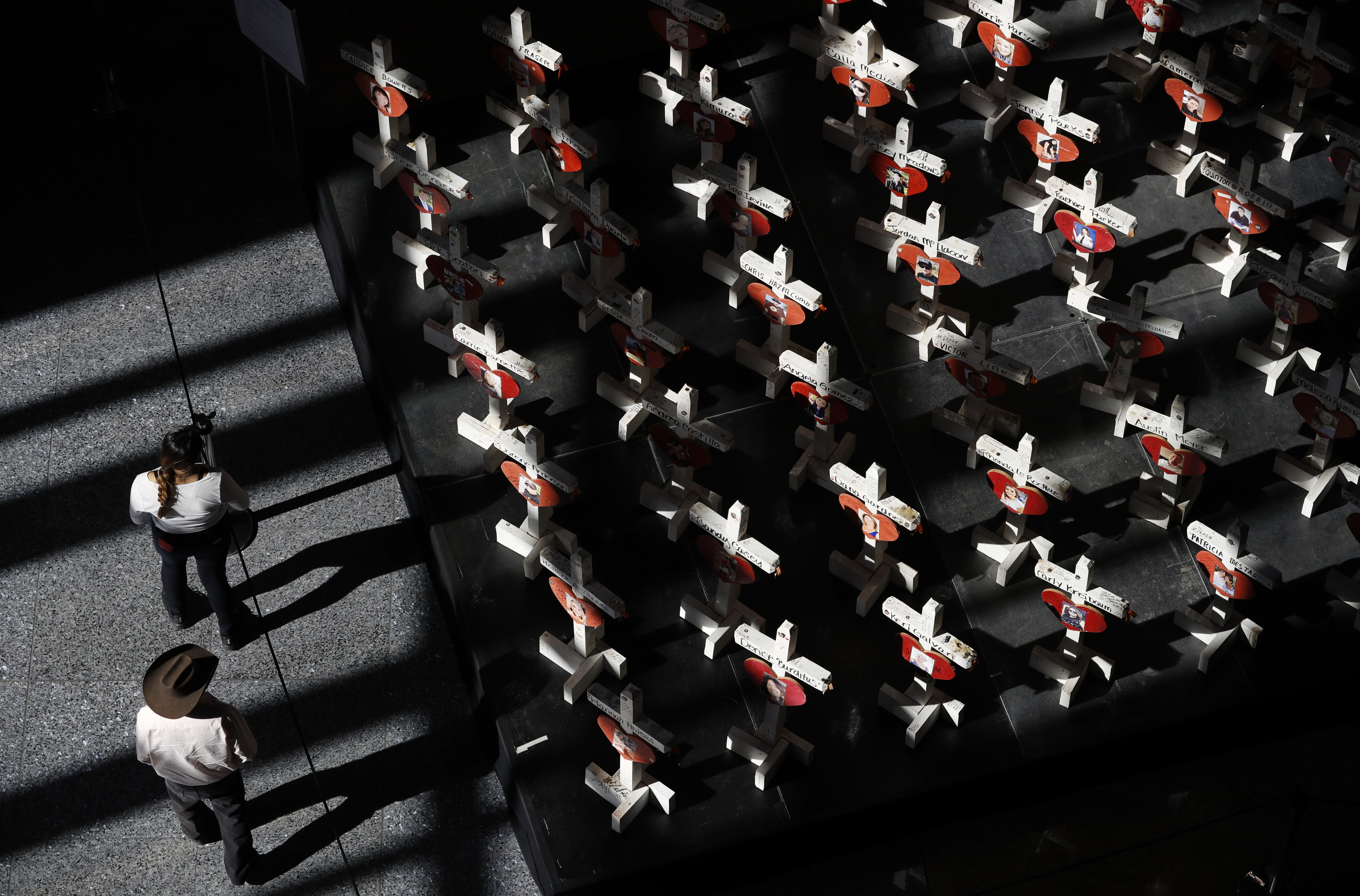 People look at a display of wooden crosses and a Star of David on display at the Clark County Government Center in Las Vegas, Sept. 25, 2018. It was the deadliest mass shooting in modern U.S. history on the Las Vegas Strip in 2017. More than 100 people have been killed in mass shootings thus far in 2023, an average of one mass killing a week.