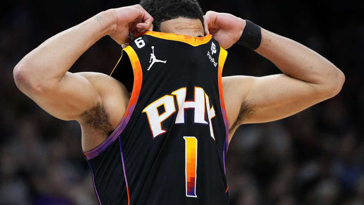 Phoenix Suns guard Devin Booker (1) hides his face after a call during the second half of Game 4 of an NBA basketball Western Conference semifinal game against the Denver Nuggets, Sunday, May 7, 2023, in Phoenix. The Suns defeated the Nuggets 129-124.