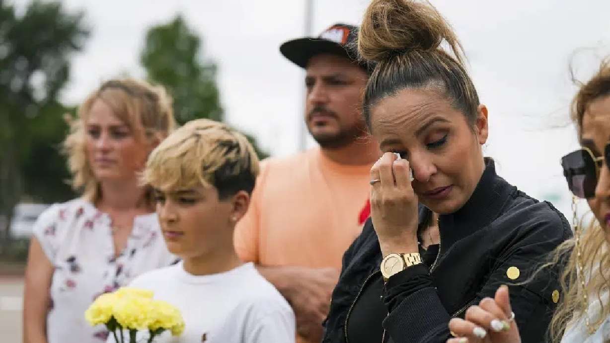 Sara Tabatabaie wipes away a tear at a memorial outside an entrance to the parking lot of the mall a day after a mass shooting at Allen Premium Outlets on Sunday in Allen, Texas.