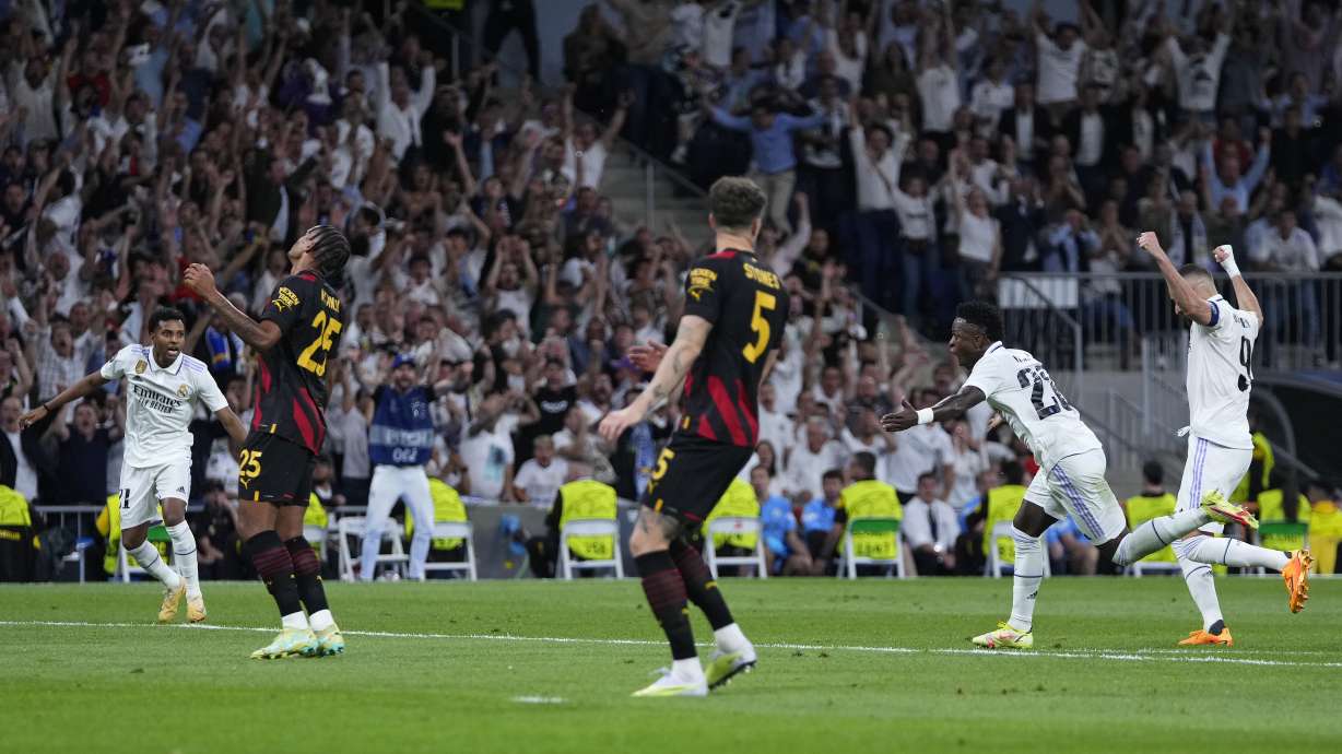 Real Madrid's Vinicius Junior, second right, celebrates after scoring the opening goal during the Champions League semifinal first leg soccer match between Real Madrid and Manchester City at the Santiago Bernabeu stadium in Madrid, Spain, Tuesday, May 9, 2023.
