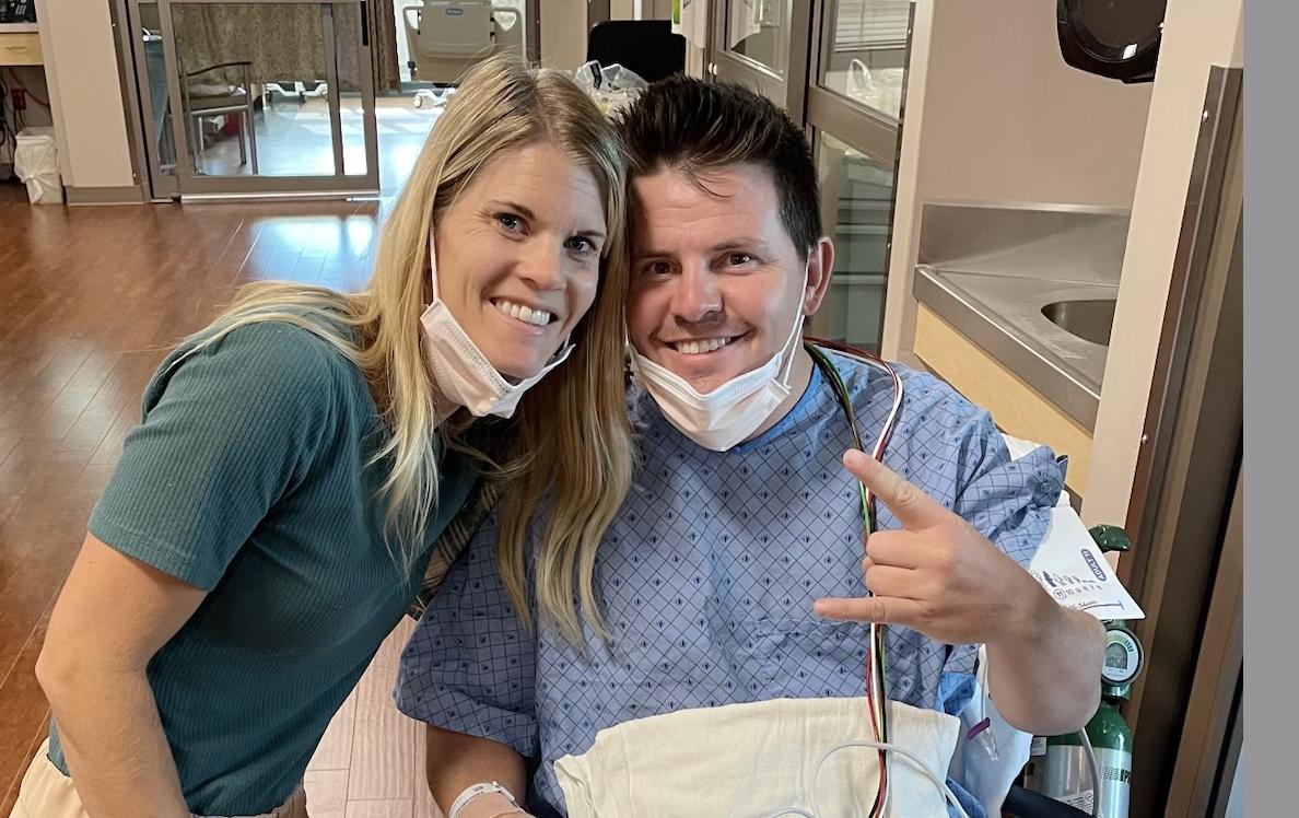 Melissa Coleman crouches next to her husband, Brad Coleman, of North Ogden, who sits in a wheelchair at Intermountain Health's McKay-Dee Hospital on Oct. 10, 2022.