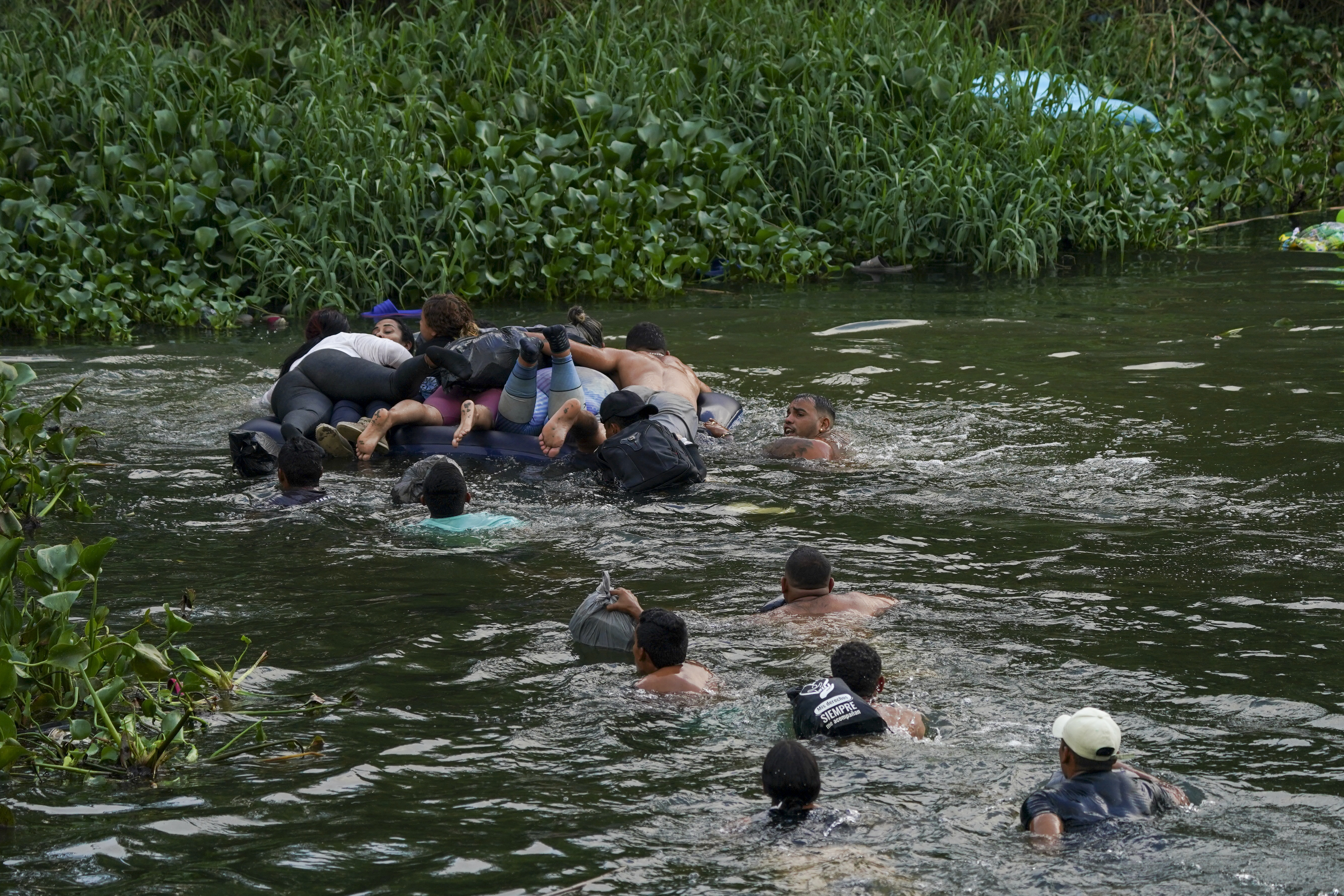 Migrants cross the Rio Bravo into the United States from Matamoros, Mexico, Tuesday. The U.S. is preparing for the Thursday end of the Title 42 policy, linked to the coronavirus pandemic, that allowed it to quickly expel many migrants seeking asylum. 