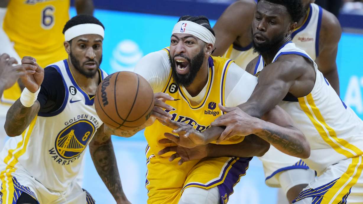 Los Angeles Lakers forward Anthony Davis, middle, reaches for the ball between Golden State Warriors guard Gary Payton II (8) and forward Andrew Wiggins during the first half of Game 5 of an NBA basketball second-round playoff series Wednesday, May 10, 2023, in San Francisco.