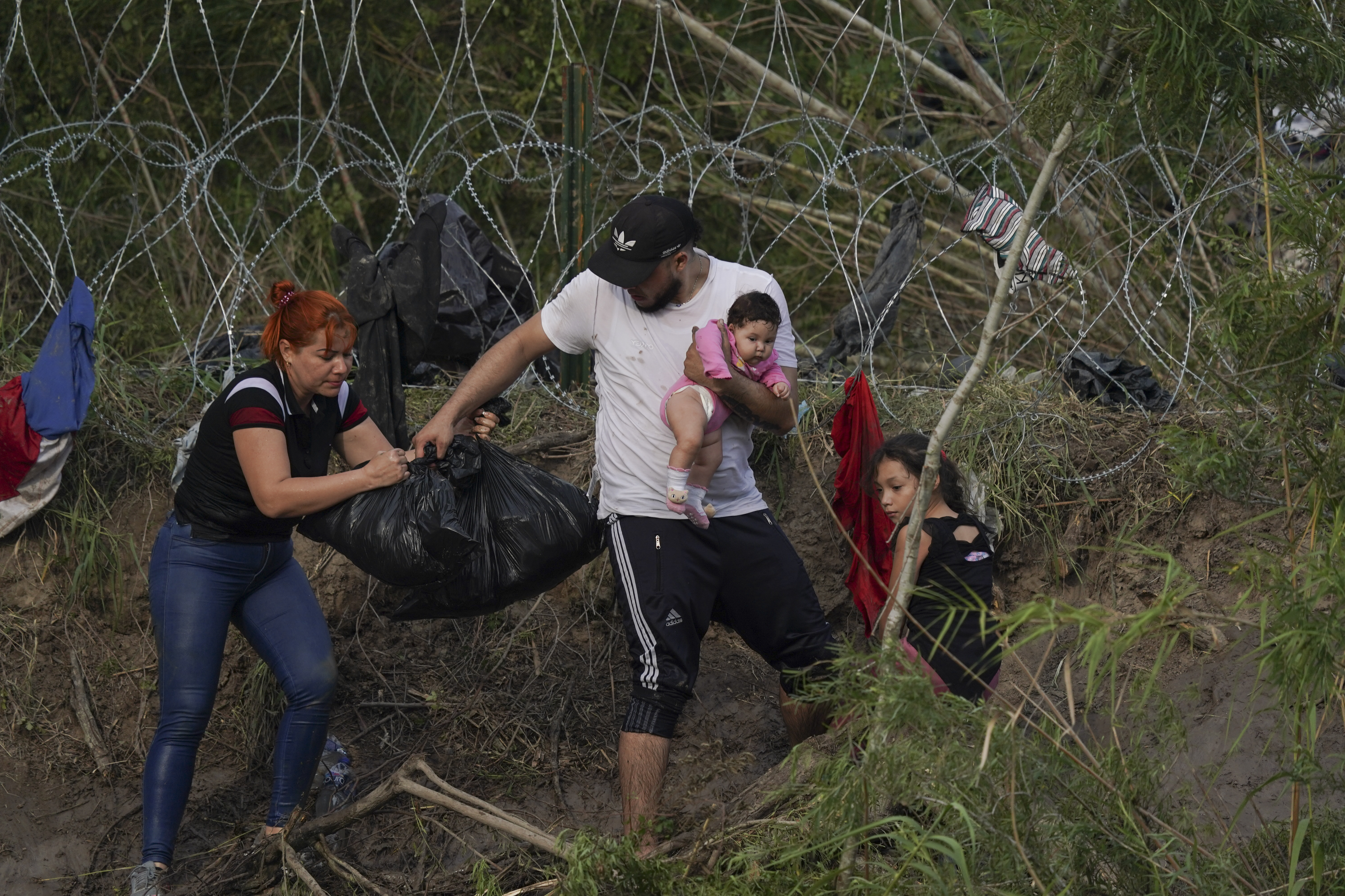 Migrants walk up the bank on the U.S. side of the Rio Grande river, as seen from Matamoros, Mexico, Wednesday. Asylum seekers have been showing up at the US-Mexico border in huge numbers in anticipation of the restriction of Title 42, that had allowed the government to quickly expel migrants to Mexico.