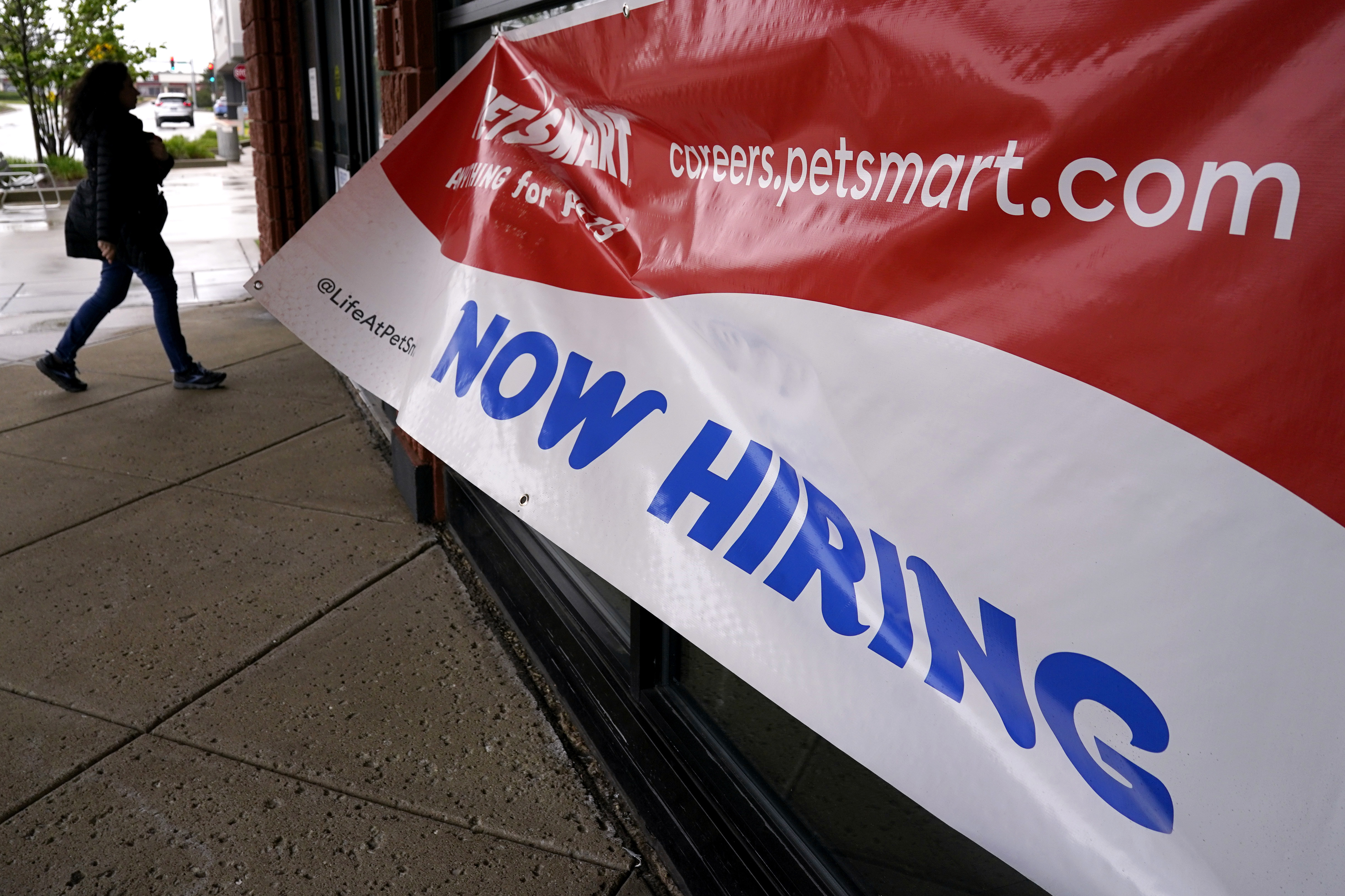 A hiring sign is displayed at a retail store in Downers Grove, Ill., May 1. The Labor Department reported Thursday that applications for unemployment benefits for the week ending May 6 rose by 22,000 to 264,000.