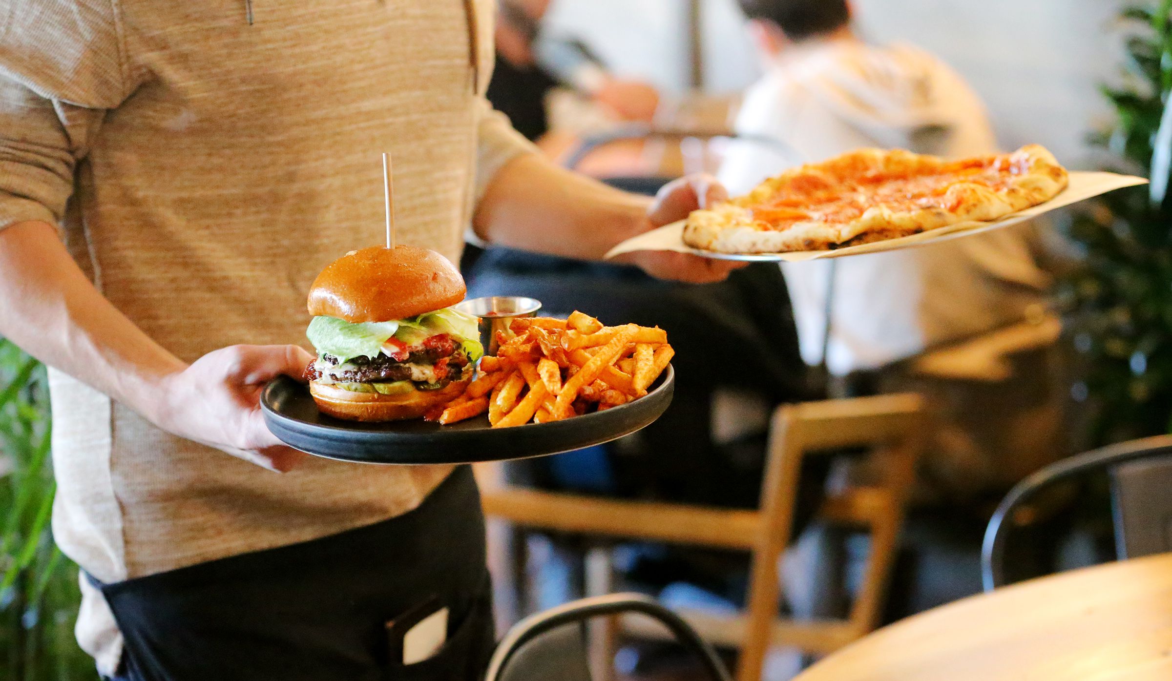 Server Shade Hammand delivers an order to a table at Oak Wood Fire Kitchen in Draper on Dec. 8, 2020.