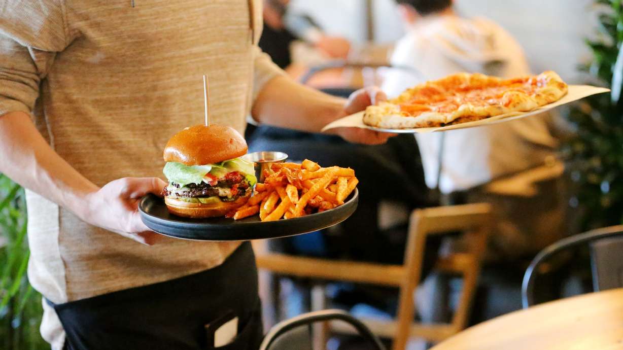 Server Shade Hammand delivers an order to a table at Oak Wood Fire Kitchen in Draper on Dec. 8, 2020.