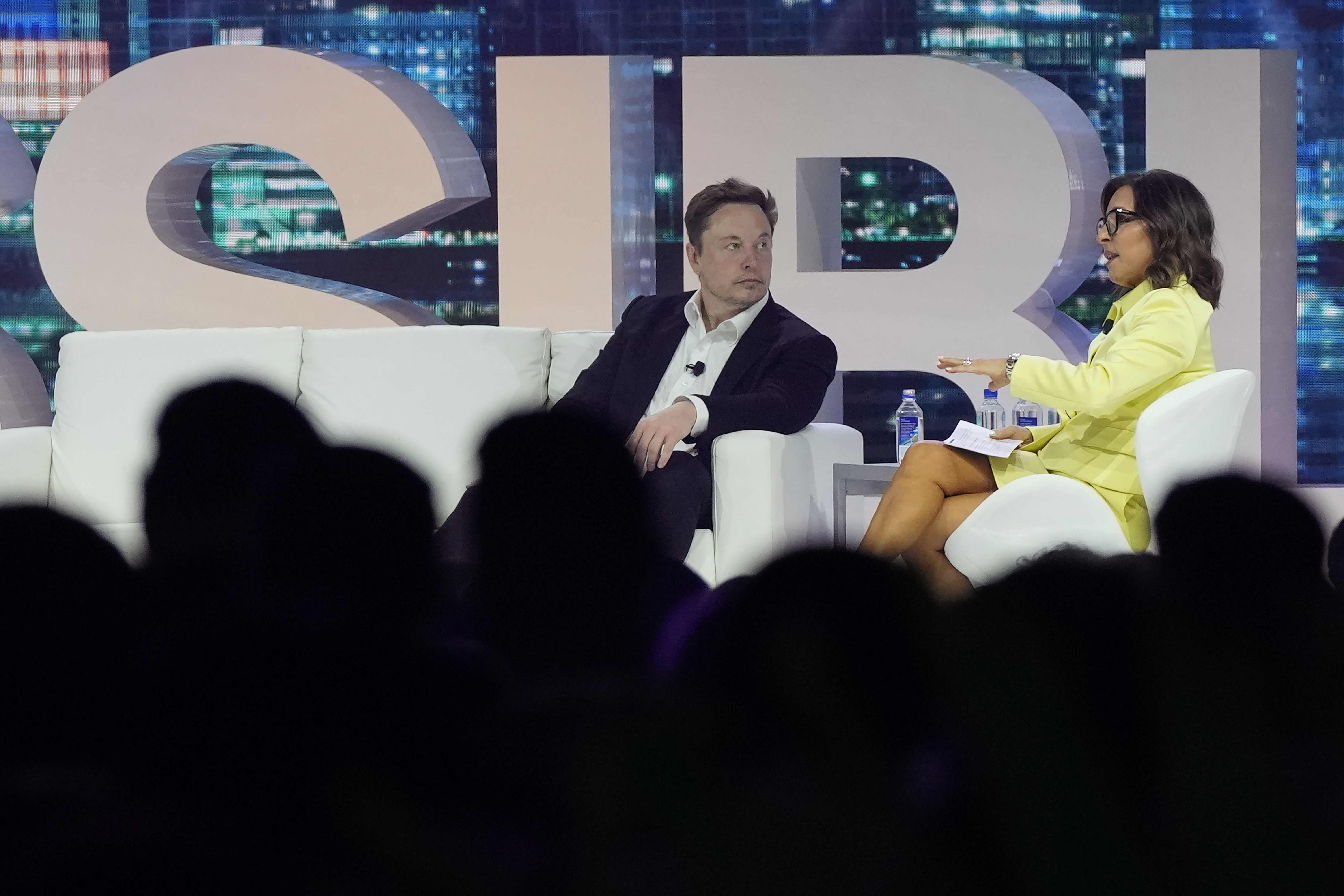 Twitter CEO Elon Musk, center, speaks with Linda Yaccarino, chairman of global advertising and partnerships for NBC, at the POSSIBLE marketing conference, April 18, in Miami Beach, Fla. Musk said he has found a new CEO for Twitter and multiple media reports identify her as Yaccarino.