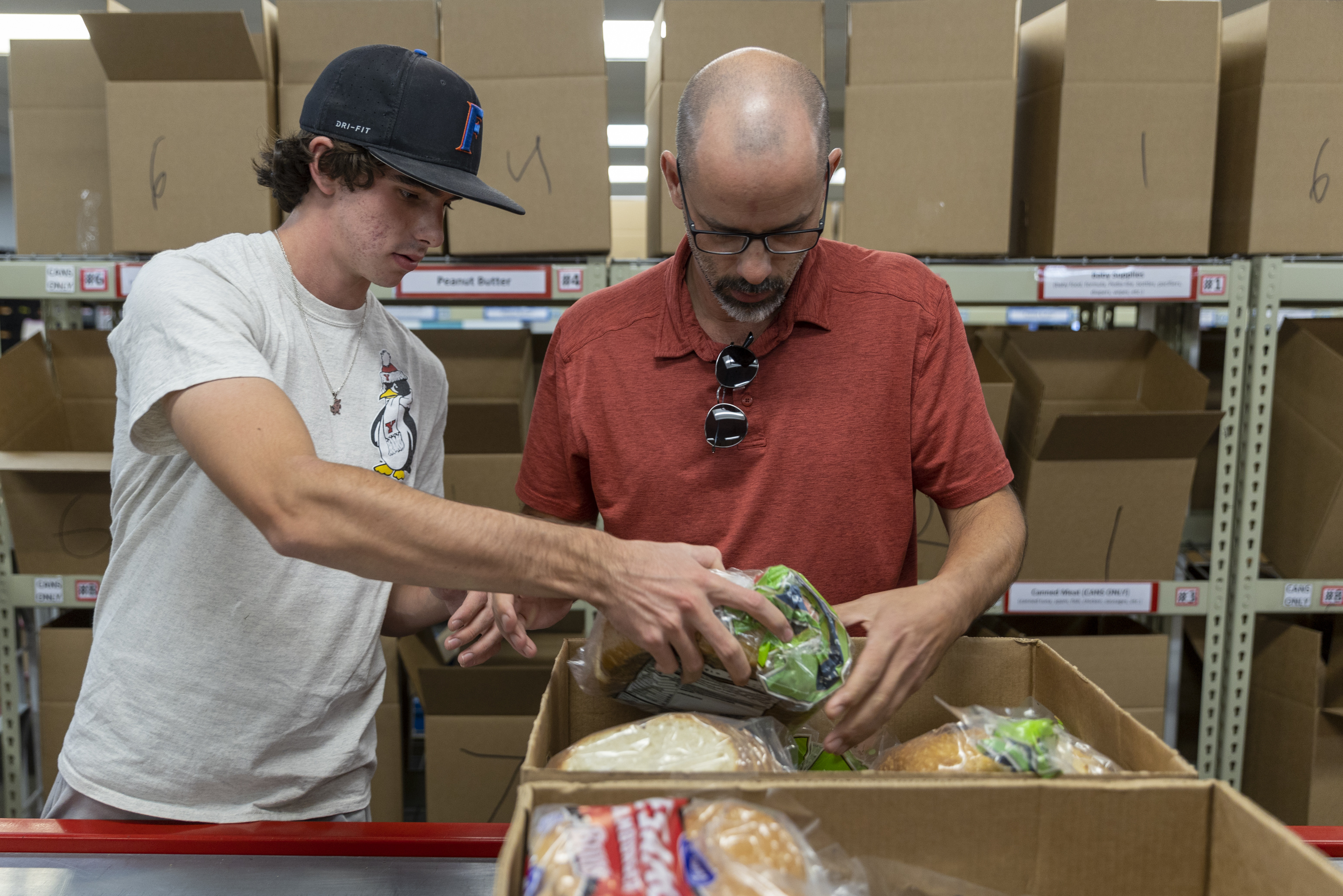 Alex Puccio volunteers with his father, Rick Puccio, at the Utah Food Bank in Salt Lake City on Oct. 3, 2022. Utahns can place a bag of nonperishable food next to their mailbox by 9 a.m. on Saturday for the 31st Stamp Out Hunger Food Drive.