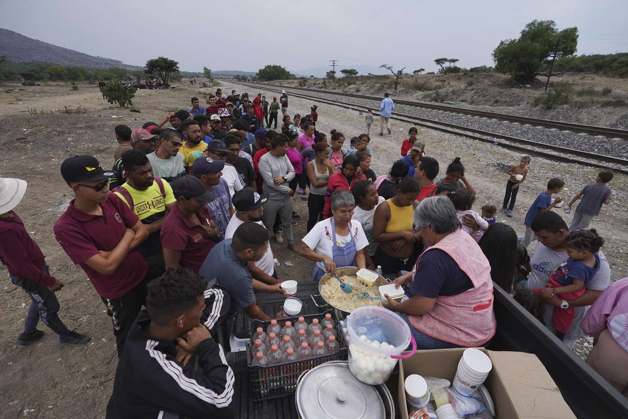 A group of nuns distributes food to migrants resting rest along the train tracks in Huehuetoca, Mexico, Friday, as they look to board a freight train heading north, the day after U.S. pandemic-related asylum restrictions called Title 42 were lifted.