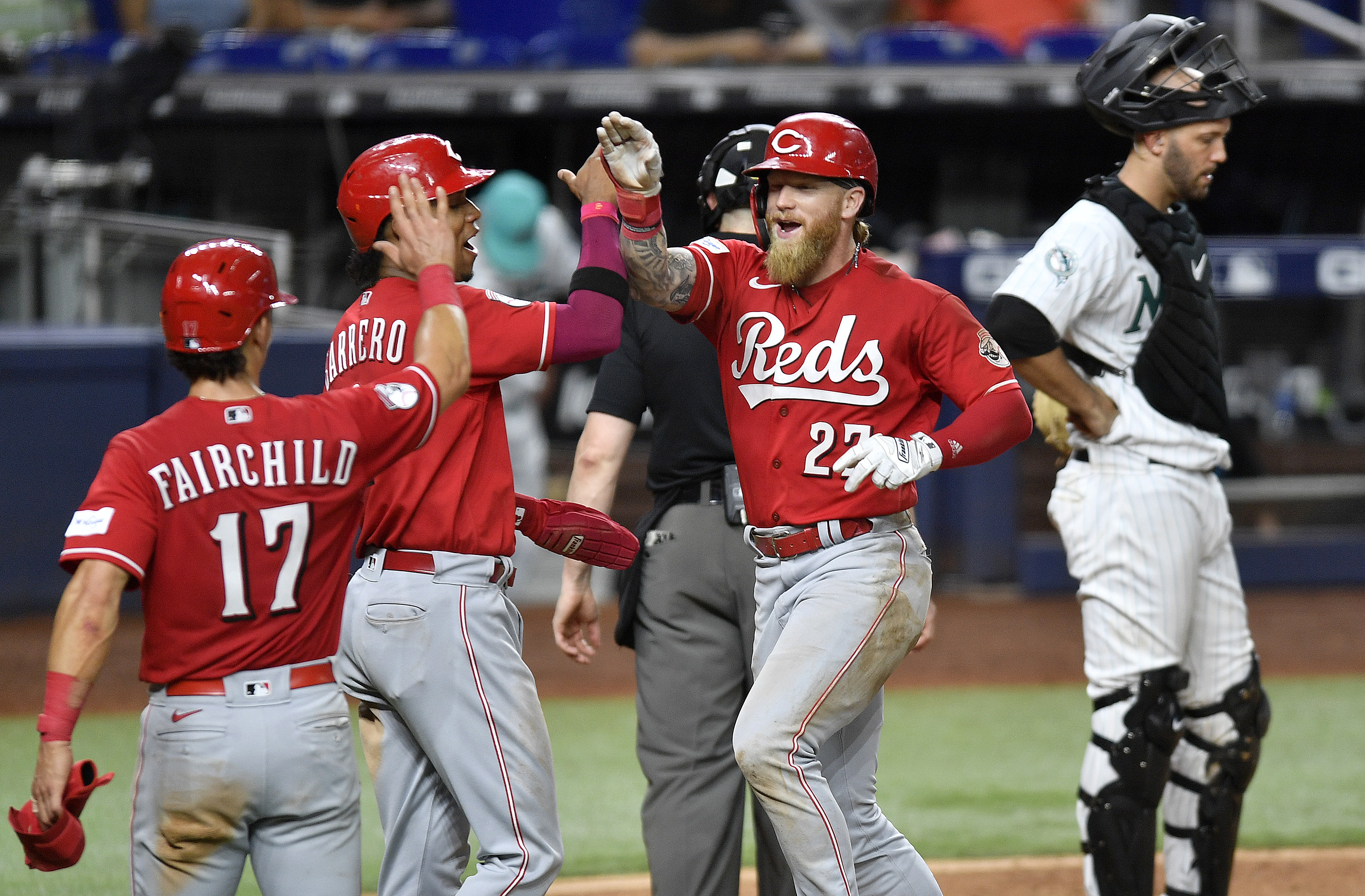 Cincinnati Reds' Jake Fraley, right front, celebrates his three-run home run with Jose Barrero and Stuart Fairchild (17) during the ninth inning of a baseball game against the Miami Marlins, Friday, May 12, 2023, in Miami. 