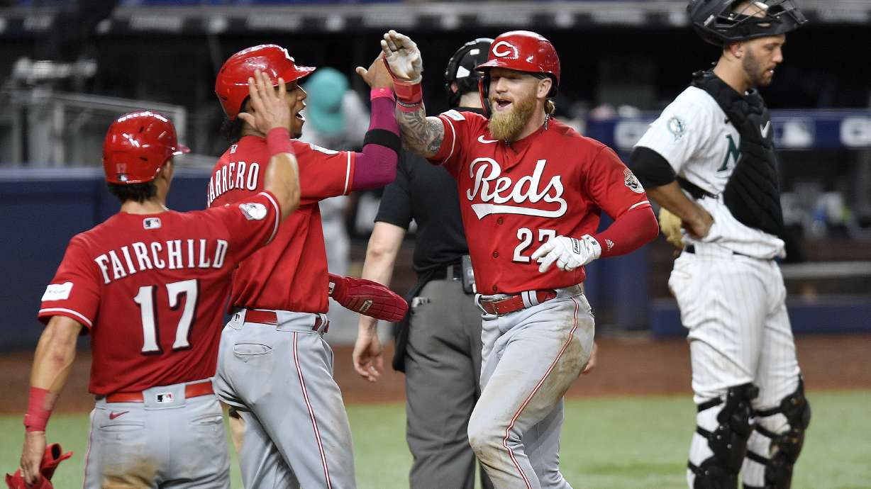 Cincinnati Reds' Jake Fraley, right front, celebrates his three-run home run with Jose Barrero and Stuart Fairchild (17) during the ninth inning of a baseball game against the Miami Marlins, Friday, May 12, 2023, in Miami.