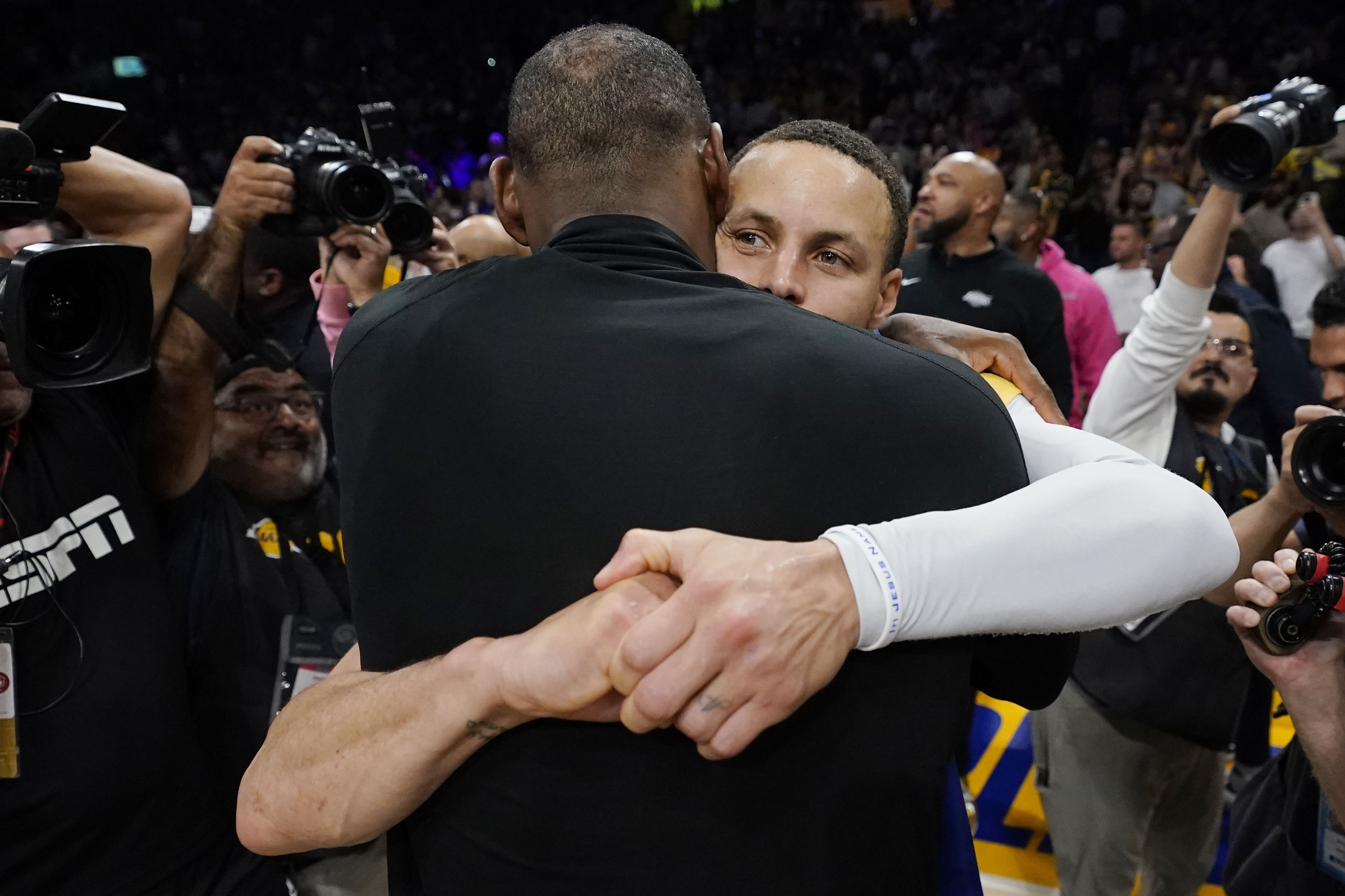 Los Angeles Lakers forward LeBron James, back to camera, hugs Golden State guard Stephen Curry after Game 6 of an NBA basketball Western Conference semifinal series Friday, May 12, 2023, in Los Angeles. Los Angeles won 122-101 to take the series and advance to the conference championship. 