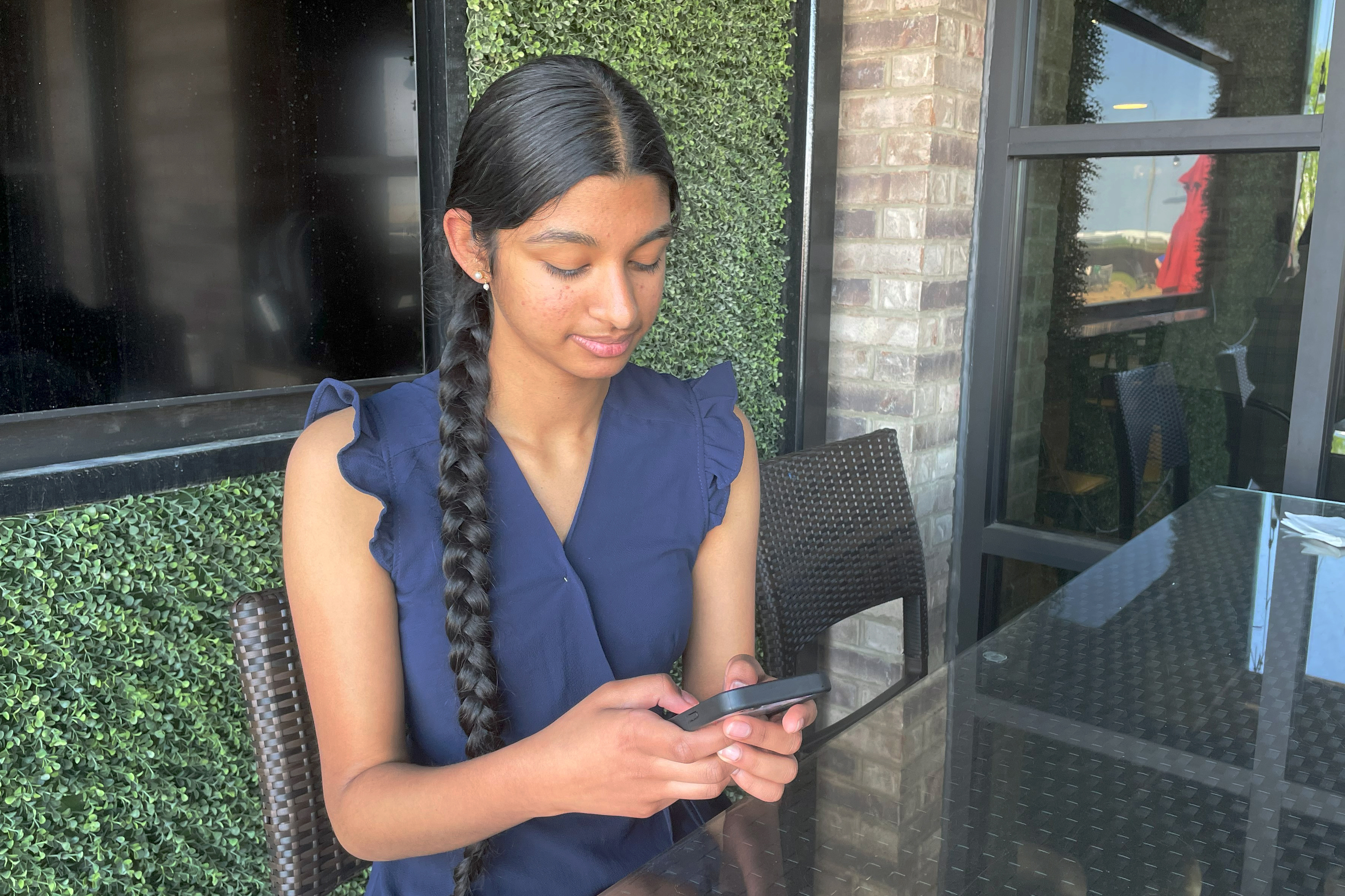 Shreya Nallamothu looks at her phone in Bloomington, Ill., on Tuesday, May 9, 2023. Illinois lawmakers aim to make their state what they say will be the first in the country to create protections for child social media influencers.