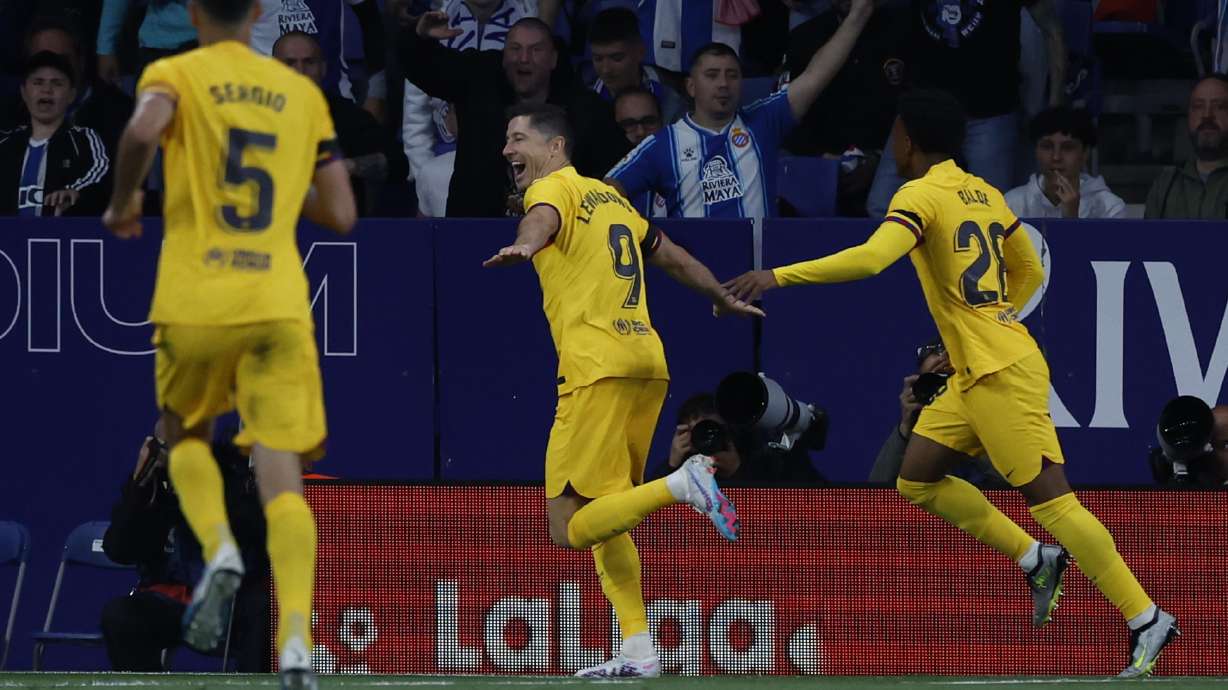 Barcelona's Robert Lewandowski, centre, celebrates after scoring his side's opening goal during the Spanish La Liga soccer match between Espanyol and Barcelona at the RCDE stadium in Barcelona, Sunday, May 14, 2023.