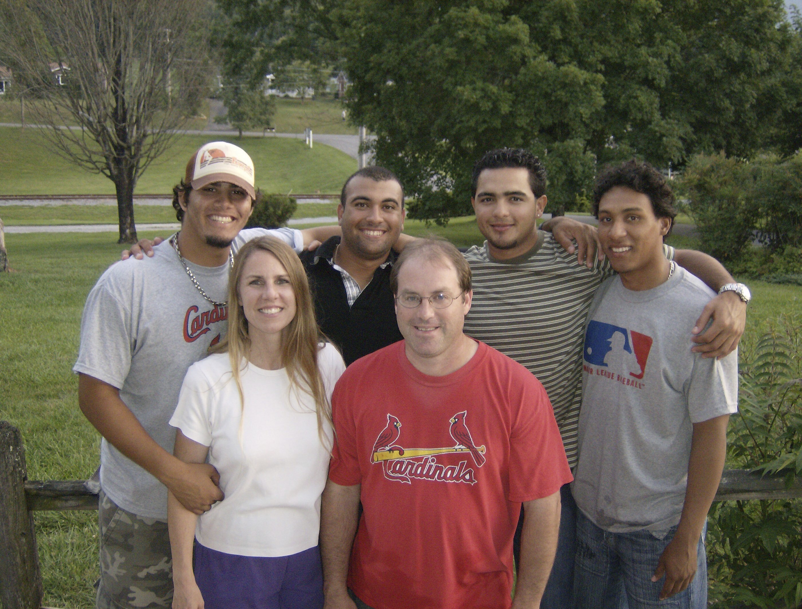 In this photo provided by TeriAnn Reynolds, TeriAnn and John Reynolds, front, pose with, from left, minor league baseball players Reynier González, Andres Rosales, Carlos Elias González and Jorge Rondón outside the Reynolds residence in Johnson City, Tenn., in July 2008. 