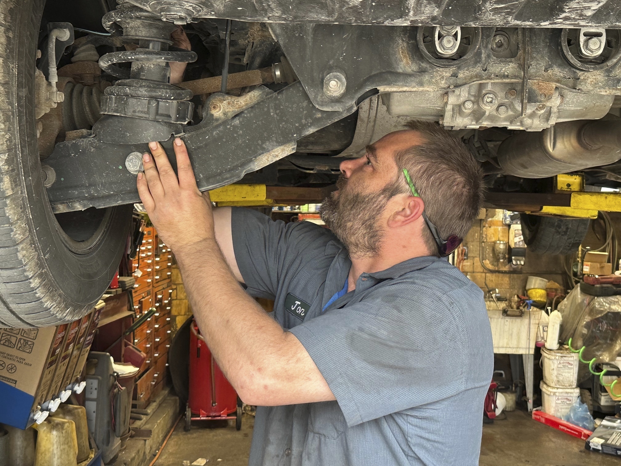 Mechanic Jon Guthrie inspects the underside of a 2014 Honda Ridgeline pickup truck at Japanese Auto Professional Service in Ann Arbor, Mich. People are keeping their vehicles longer due to shortages of new ones and high prices. 