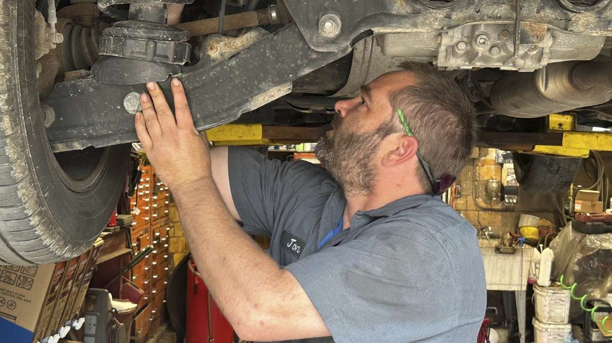 Mechanic Jon Guthrie inspects the underside of a 2014 Honda Ridgeline pickup truck at Japanese Auto Professional Service in Ann Arbor, Mich. People are keeping their vehicles longer due to shortages of new ones and high prices.