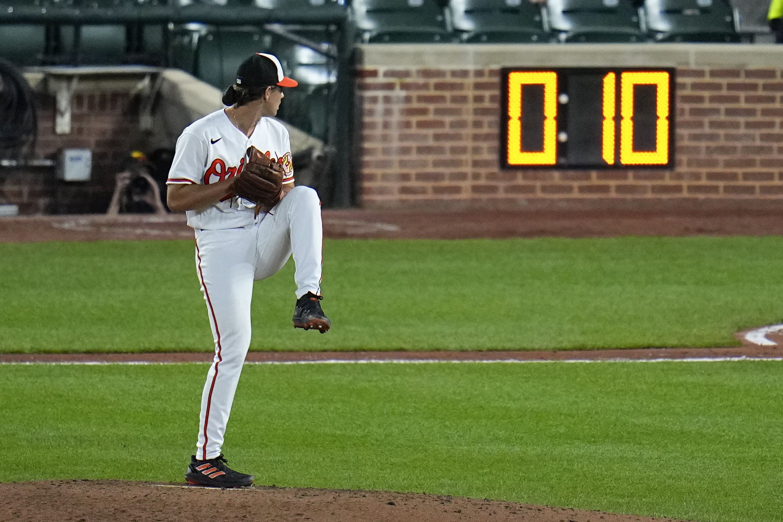 FILE - The pitch clock is visible as Baltimore Orioles starting pitcher Dean Kremer winds up to deliver during the sixth inning of a baseball game against the Boston Red Sox, April 24, 2023, in Baltimore, Md. Limits on infield shifts, a pitch clock and larger bases were implemented this year in an attempt to counter the impact of the Analytics Era suffocation of offense. 