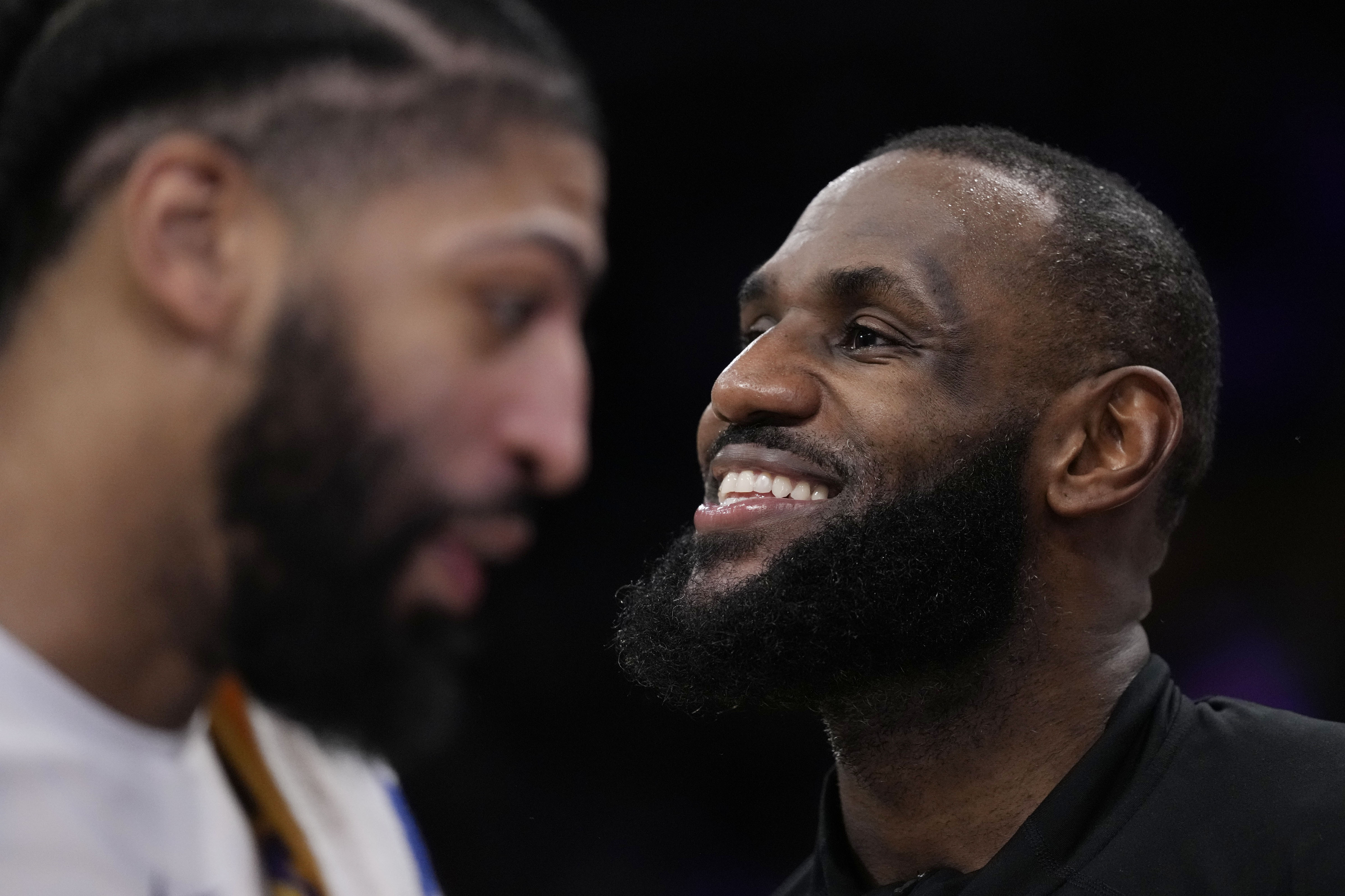 Los Angeles Lakers forward LeBron James, right, smiles next to forward Anthony Davis during the second half in Game 6 of an NBA basketball Western Conference semifinal series against the Golden State Warriors Friday, May 12, 2023, in Los Angeles. 