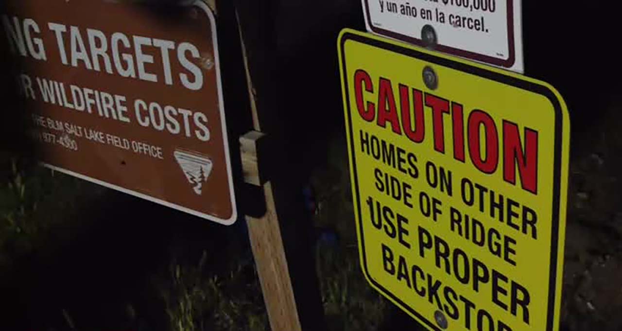 Numerous signs are visible in a target shooting area in Genola, warning prospective shooters that homes are on the other side of the ridge.
