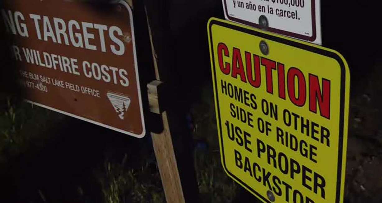Numerous signs are visible in a target shooting area in Genola, warning prospective shooters that homes are on the other side of the ridge.