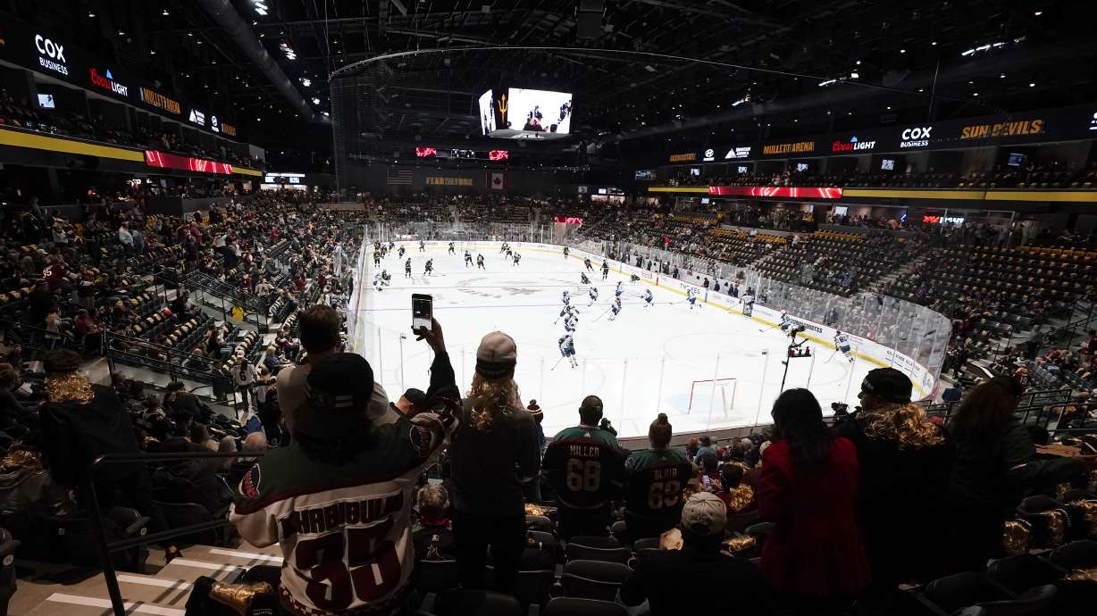 FILE - Fans watch as players warm up prior to the Arizona Coyotes' home-opening NHL hockey game against the Winnipeg Jets at the 5,000-seat Mullett Arena in Tempe, Ariz., Oct. 28, 2022. The Coyotes are about to learn the fate of a proposed entertainment district that will include a new arena. A referendum going before voters in the city of Tempe will determine whether plans for the $2.3 billion Tempe Entertainment District will move forward.