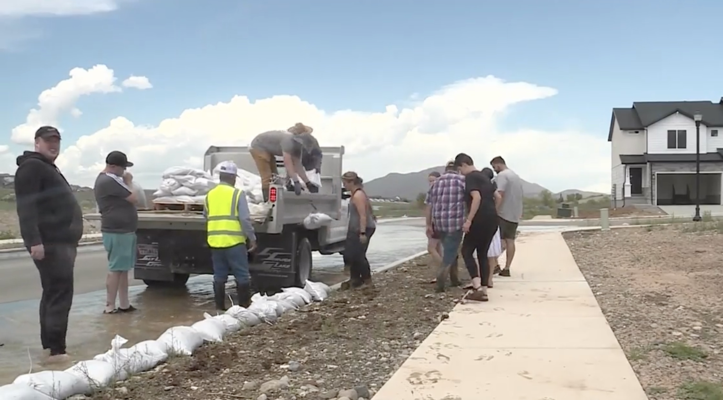Spring runoff flowed down a city street Wednesday, prompting volunteers to join sandbagging efforts as emergency managers said the road was functioning as planned.