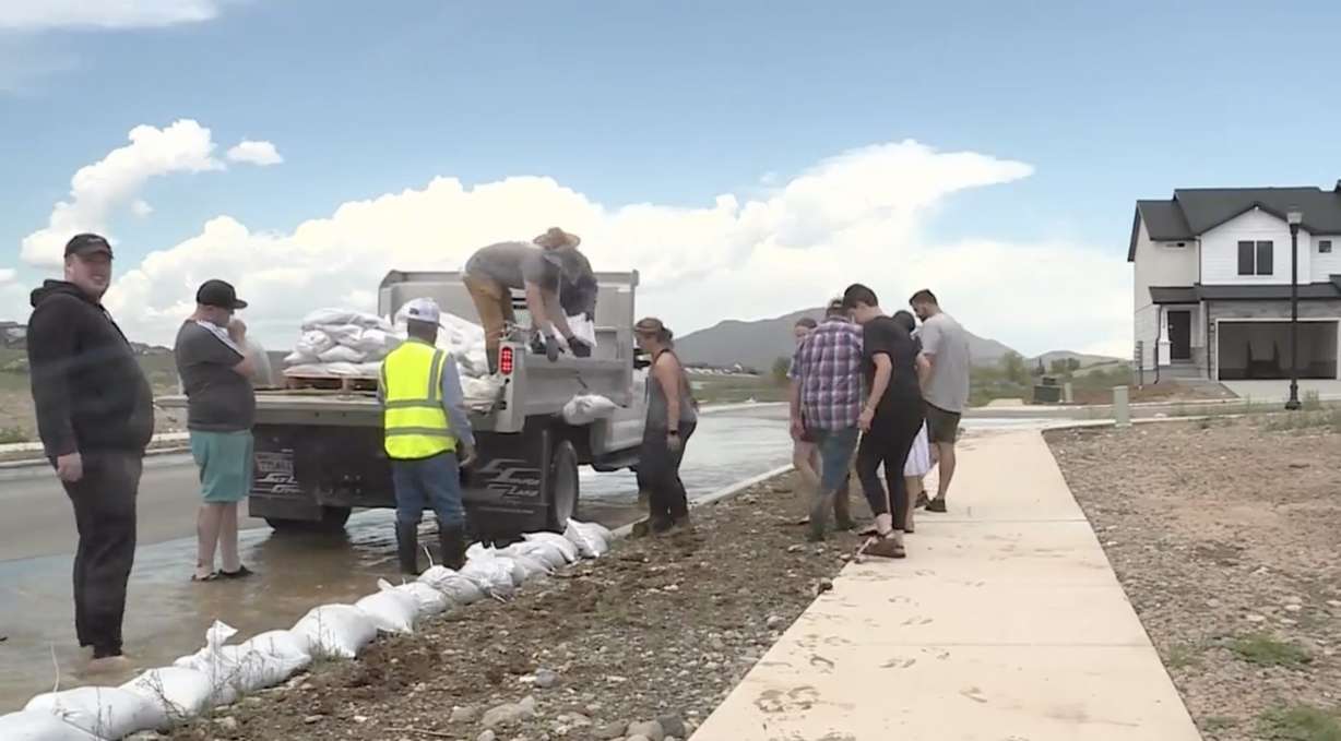 Spring runoff flowed down a city street Wednesday, prompting volunteers to join sandbagging efforts as emergency managers said the road was functioning as planned.
