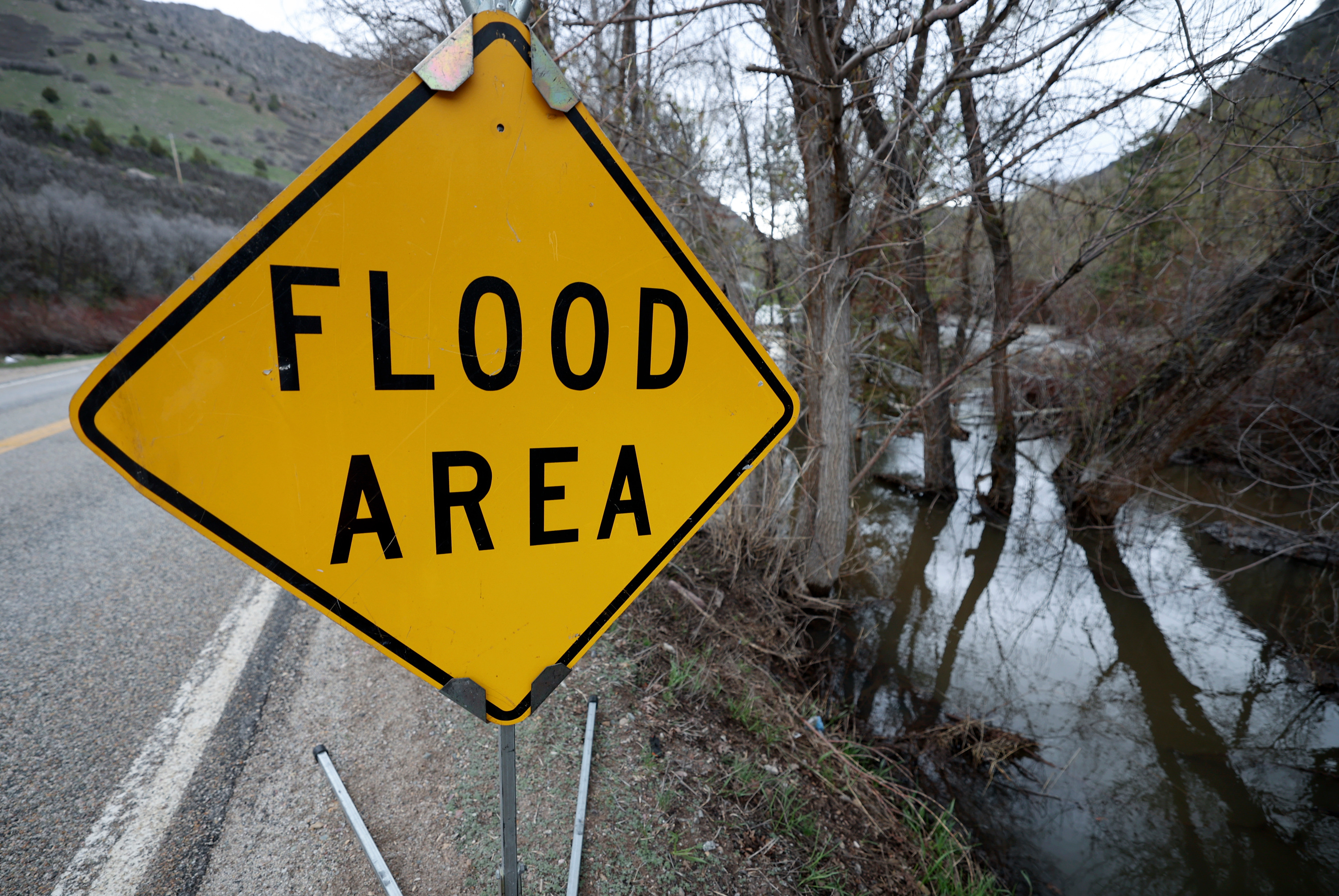 A sign warns of flooding next to the South Fork of the Ogden River after a record snowfall year in Weber County on May 8. Utah Gov. Spencer Cox said Thursday flooding and landslide risks could remain high in parts of Utah over the next few weeks.