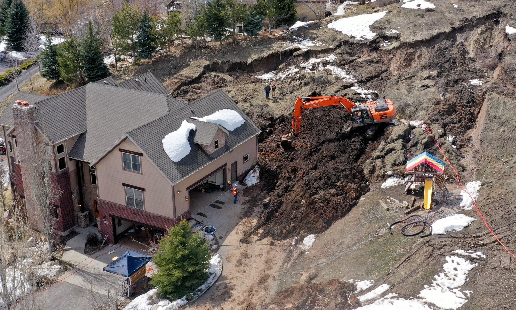 Crews work to remove mud at the scene of a mudslide in Morgan on Monday. This year's record snowpack along with saturated soils have led to 100 documented landslides across the state. 