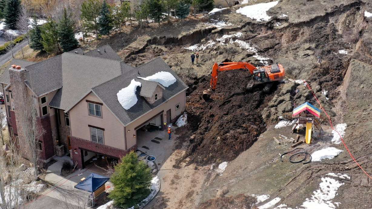 Crews work to remove mud at the scene of a mudslide in Morgan on Monday. This year's record snowpack along with saturated soils have led to 100 documented landslides across the state.