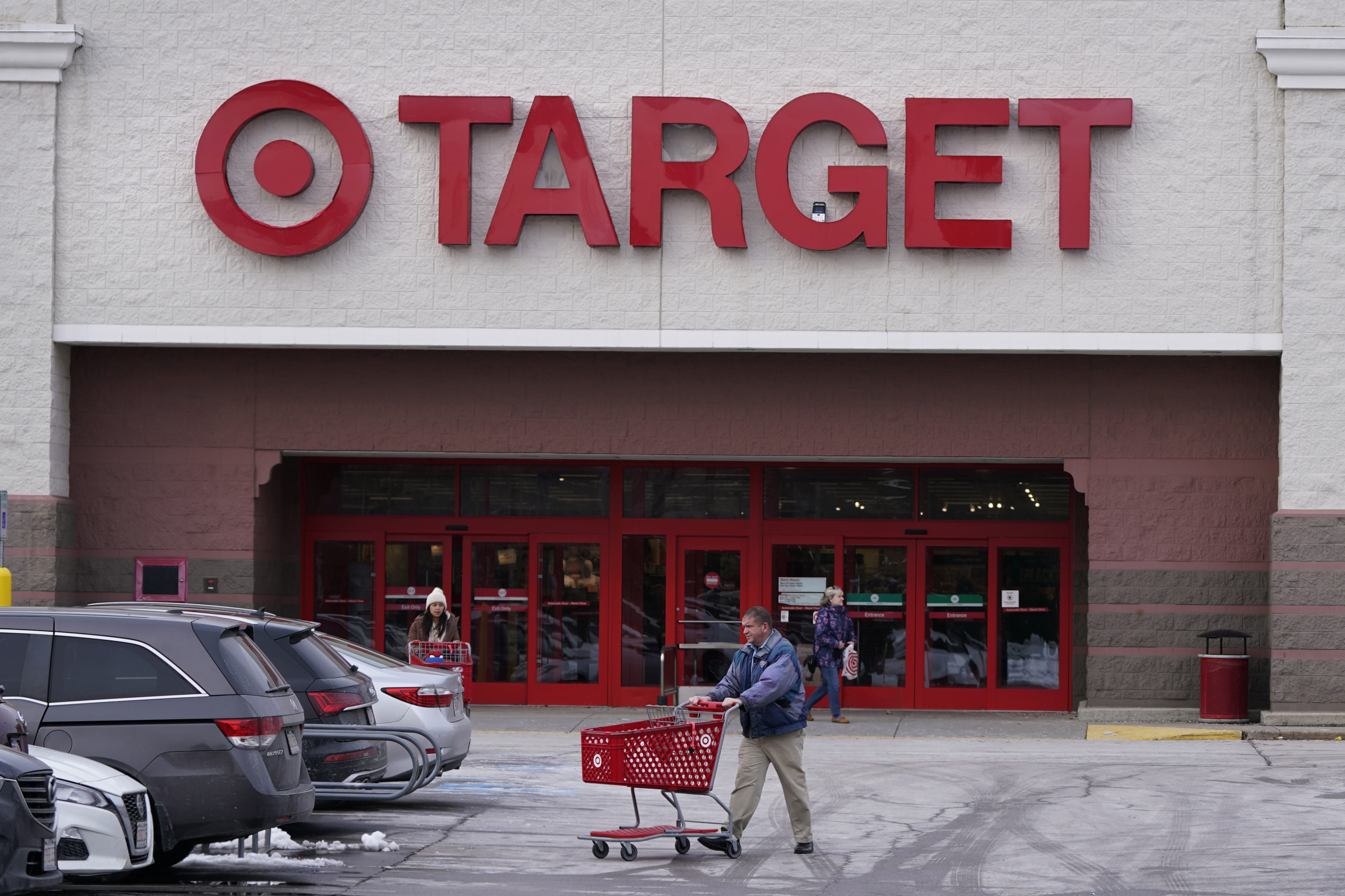 A shopper wheels a cart through the parking lot after making a purchase at the Target store, Feb. 27, in Salem, N.H. Target is recalling almost 5 million candles over laceration and burn hazards, according to a Thursday notice published by the U.S. Consumer Product Safety Commission.
