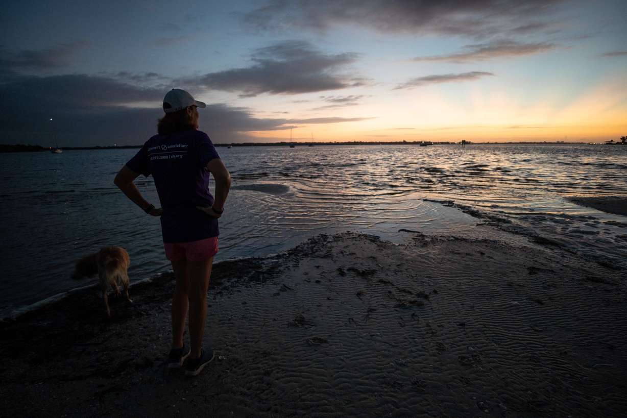 Michele Hall, 55, of Bradenton, Fla., watches the sunrise during her morning walk at the De Soto National Memorial on Sunday, Sept. 25, 2022, in Bradenton. Hall was diagnosed with Alzheimer’s disease when she was 53. “I can’t read or write or any of that stuff. But I can talk.”