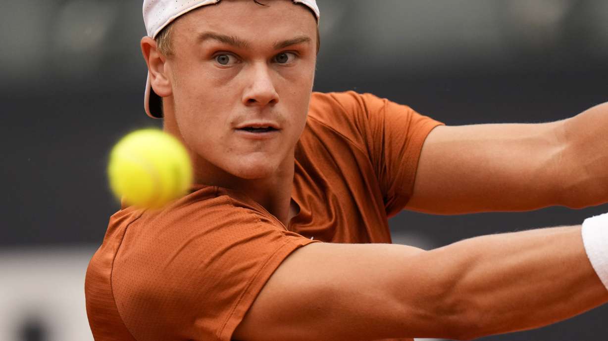 Denmark's Holger Rune returns the ball during a semi final match against Norway's Casper Ruud at the Italian Open tennis tournament in Rome, Italy, Saturday, May 20, 2023.